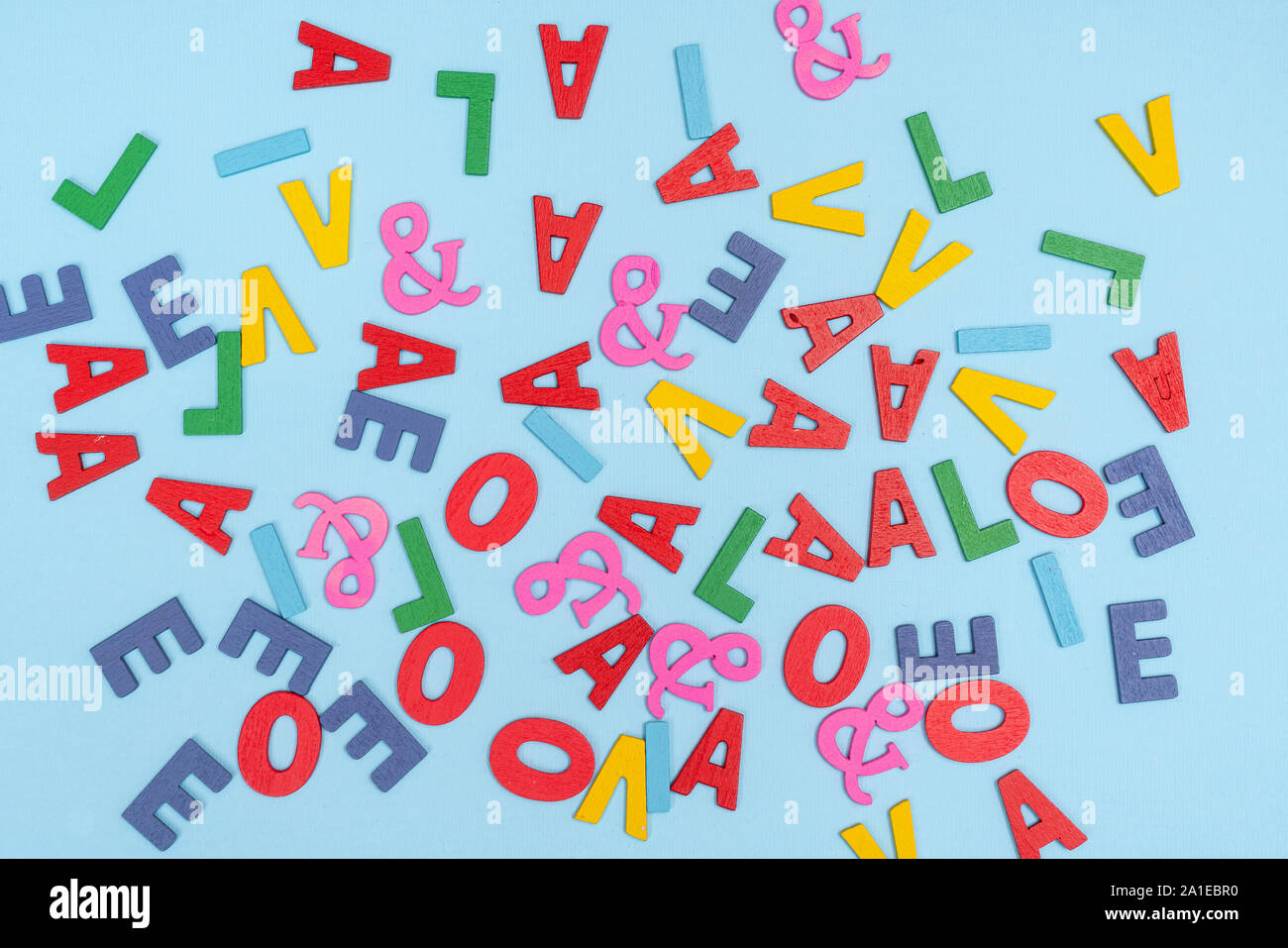 Certaines lettres de l'alphabet coloré en ordre dispersé sur une surface colorée Banque D'Images