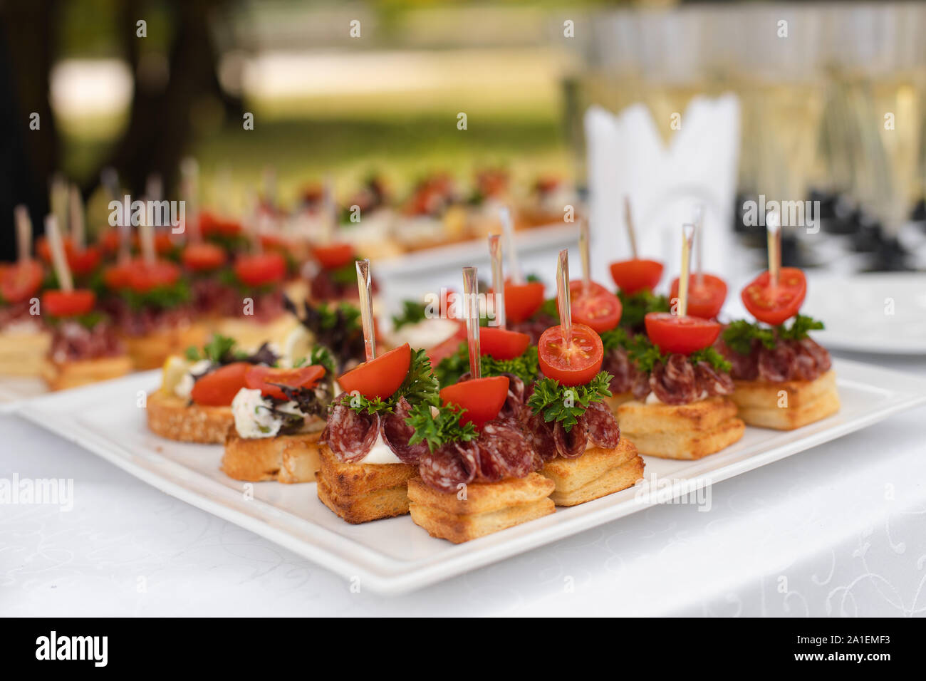 Close-up grande assiette avec des snack-canapes pain frit et persil tomate salami Banque D'Images