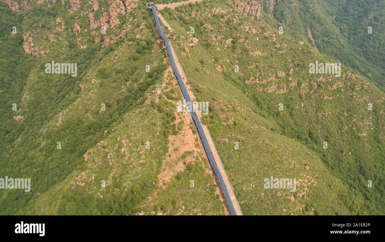 Le 26 septembre 2019, le Henan, Henan, Chine : Henan, Chine-photo aérienne prise le 25 septembre 2019 montre une route sinueuse de montagne dans l'escalator géant fuxi mountain, le centre de la Chine, la province du Henan...Il est rapporté que l'escalier se compose de six visites d'ascenseurs, d'une longueur totale de 518 mètres et une chute de 180 mètres.à partir du bas de l'échelle vers le ciel, comme un dragon géant planant au-dessus de la crête. (Crédit Image : © SIPA l'Asie via Zuma sur le fil) Banque D'Images