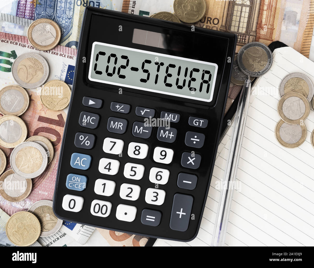 Close-up of CO2 Steuer, texte en allemand, pour taxe carbone, sur l'écran de calculatrice de poche contre l'introduction des billets sur la table Banque D'Images