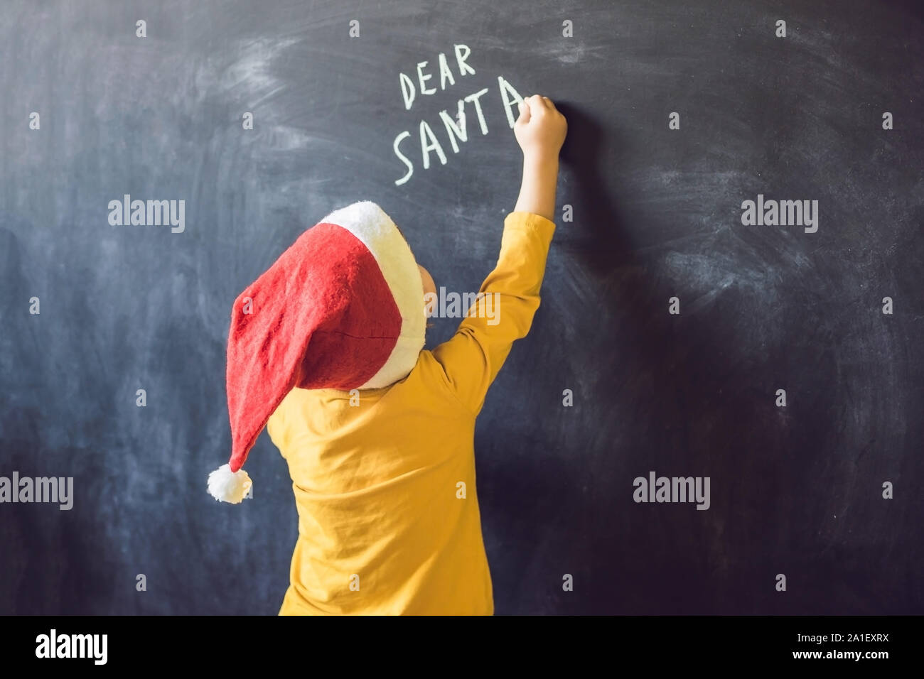Cher Père Noël. Le garçon a écrit un message pour le Père Noël. Noël. Banque D'Images