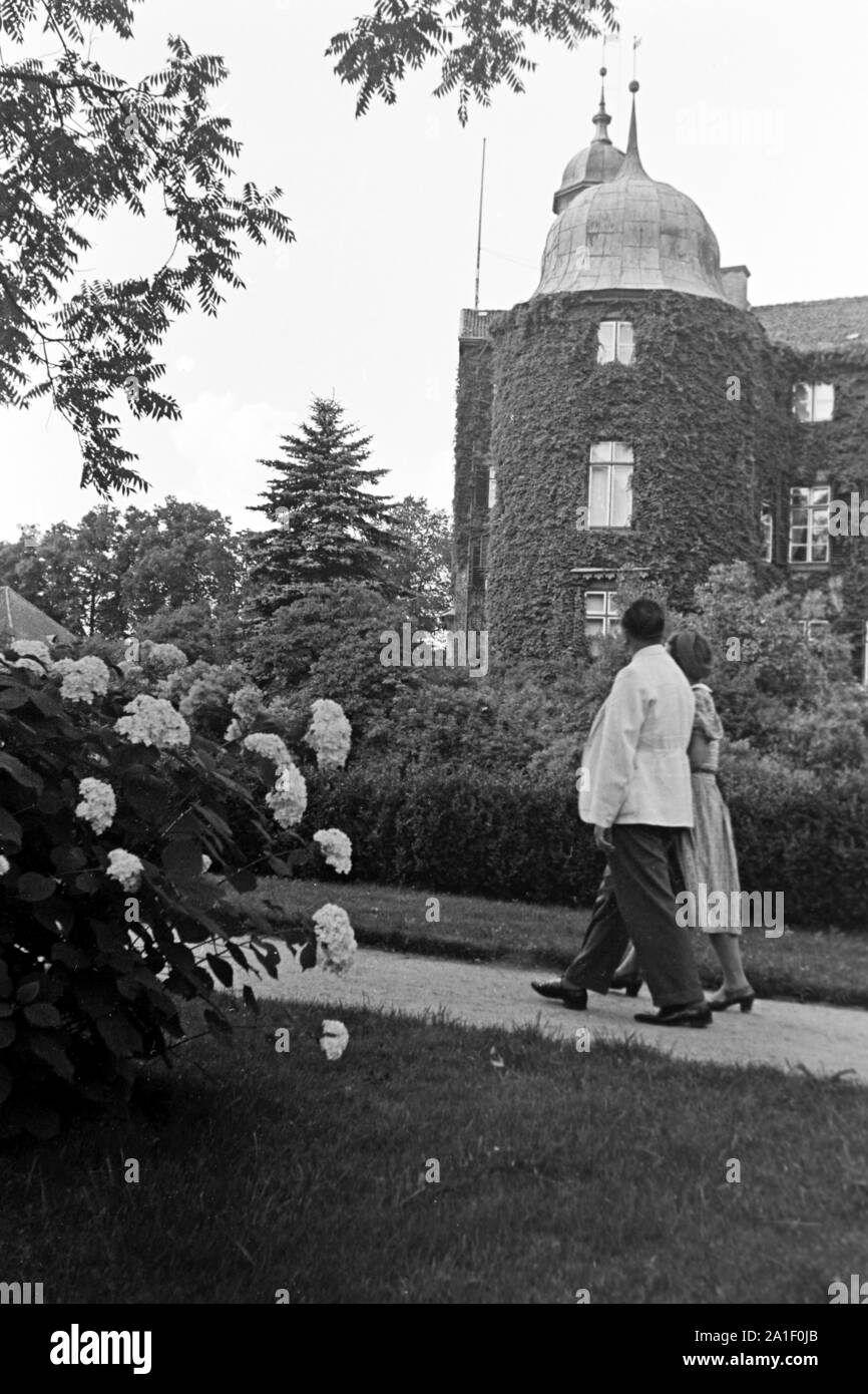 Ein Paar une spaziert mit einem Schloss, bewachsen Efeu entlang, Deutschland 1939. Un couple strolling près d'un château qui est plein de lierre, Allemagne 1939. Banque D'Images