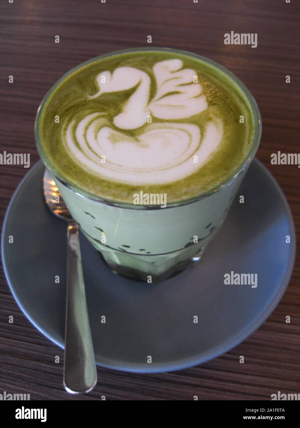 Thé vert matcha latte avec beauitiful latte art et servi dans un verre Banque D'Images