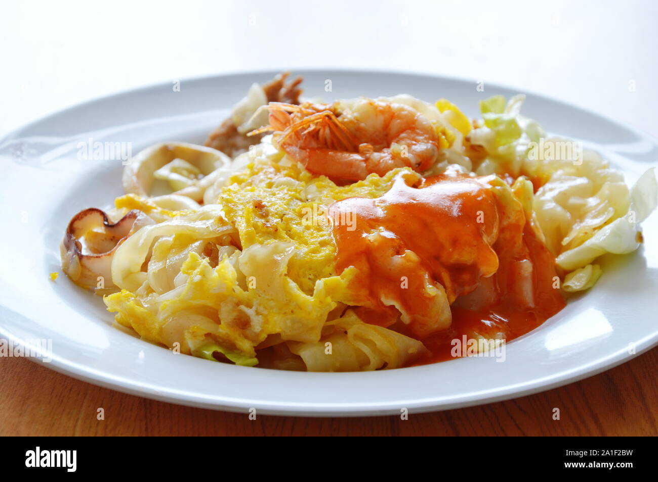 Fruits de mer de nouilles de riz sautées et sauce chili sauce chou sur lave Banque D'Images