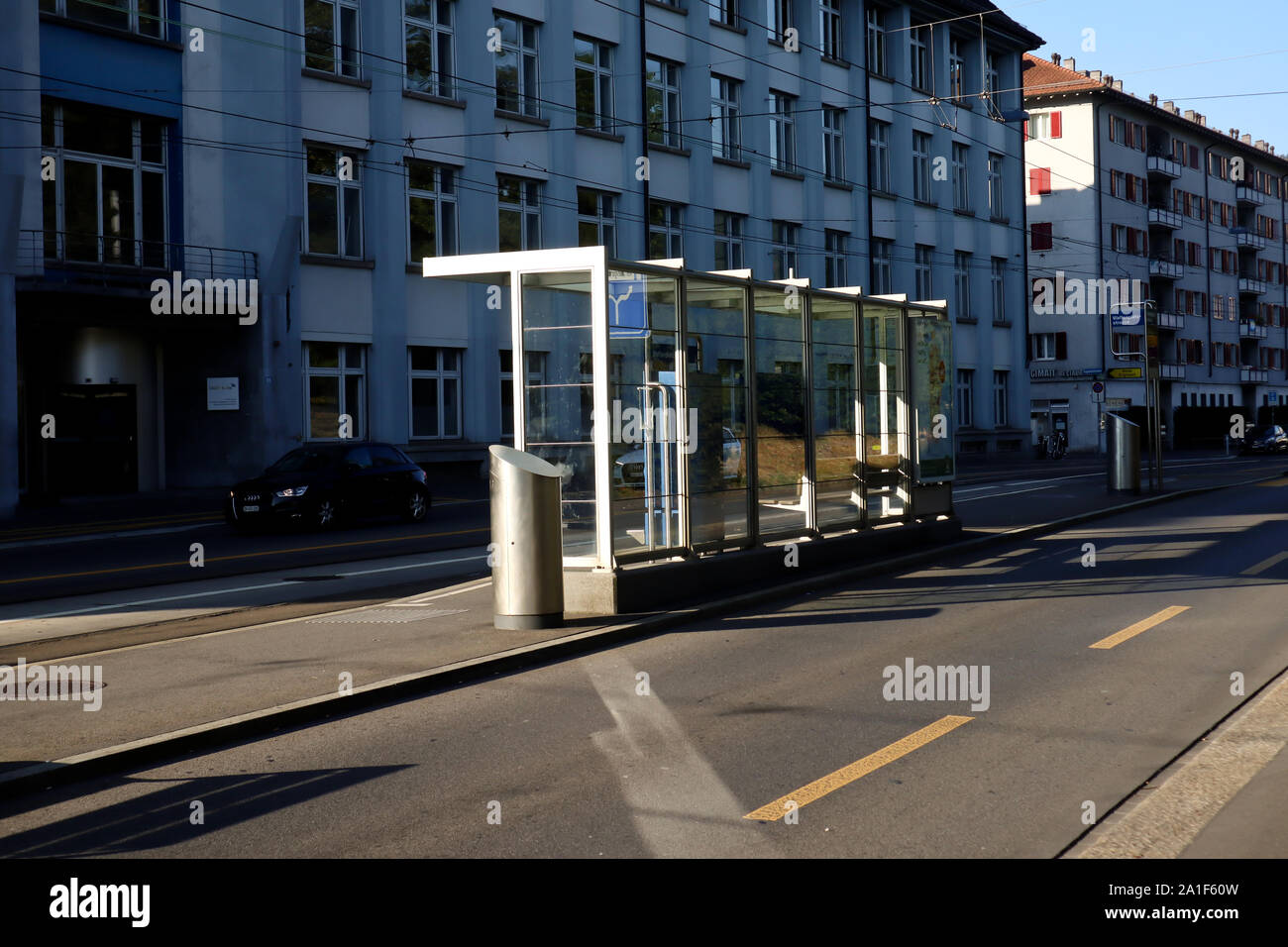 Zurich,Suisse,Juillet 22, 2019:vide de la gare routière et la rue vide à Zurich dans le matin ensoleillé abri bus à un arrêt d'autobus de verre Banque D'Images