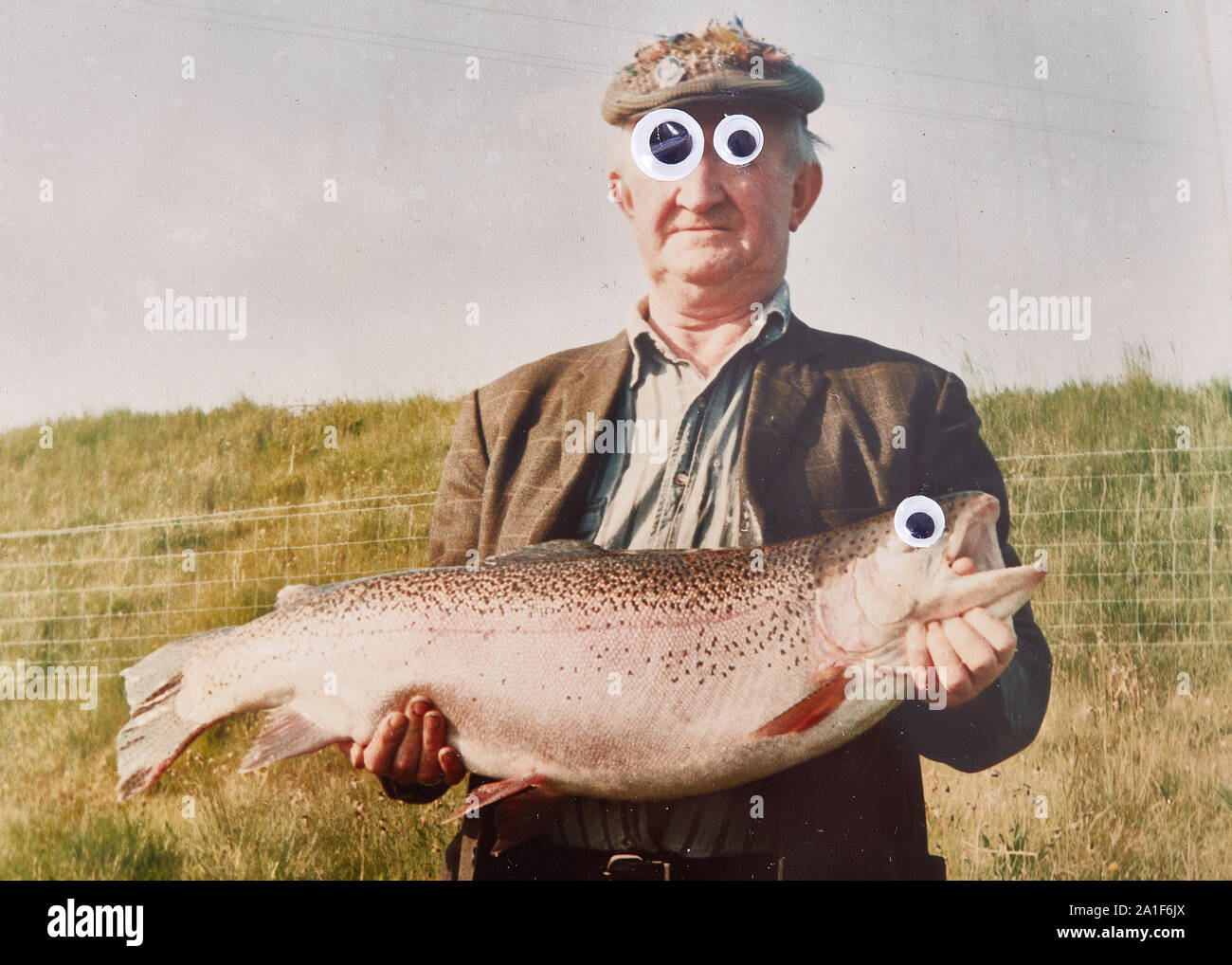 Image drôle de old man (pas reconnaissables) holding Big Fish avec googley yeux Banque D'Images