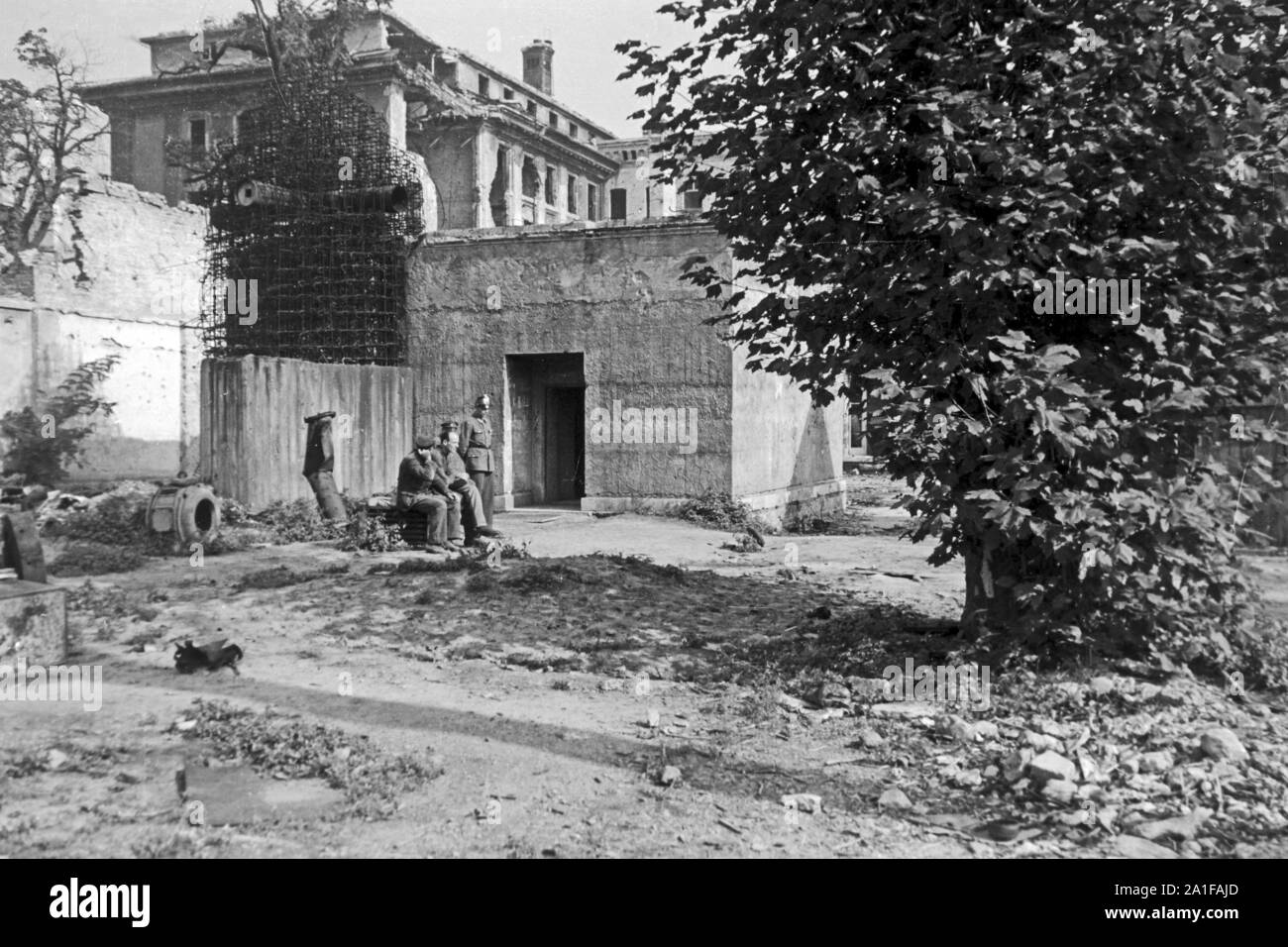 Soldaten und Polizei bewachen den Eingang zum Führerbunker im Garten