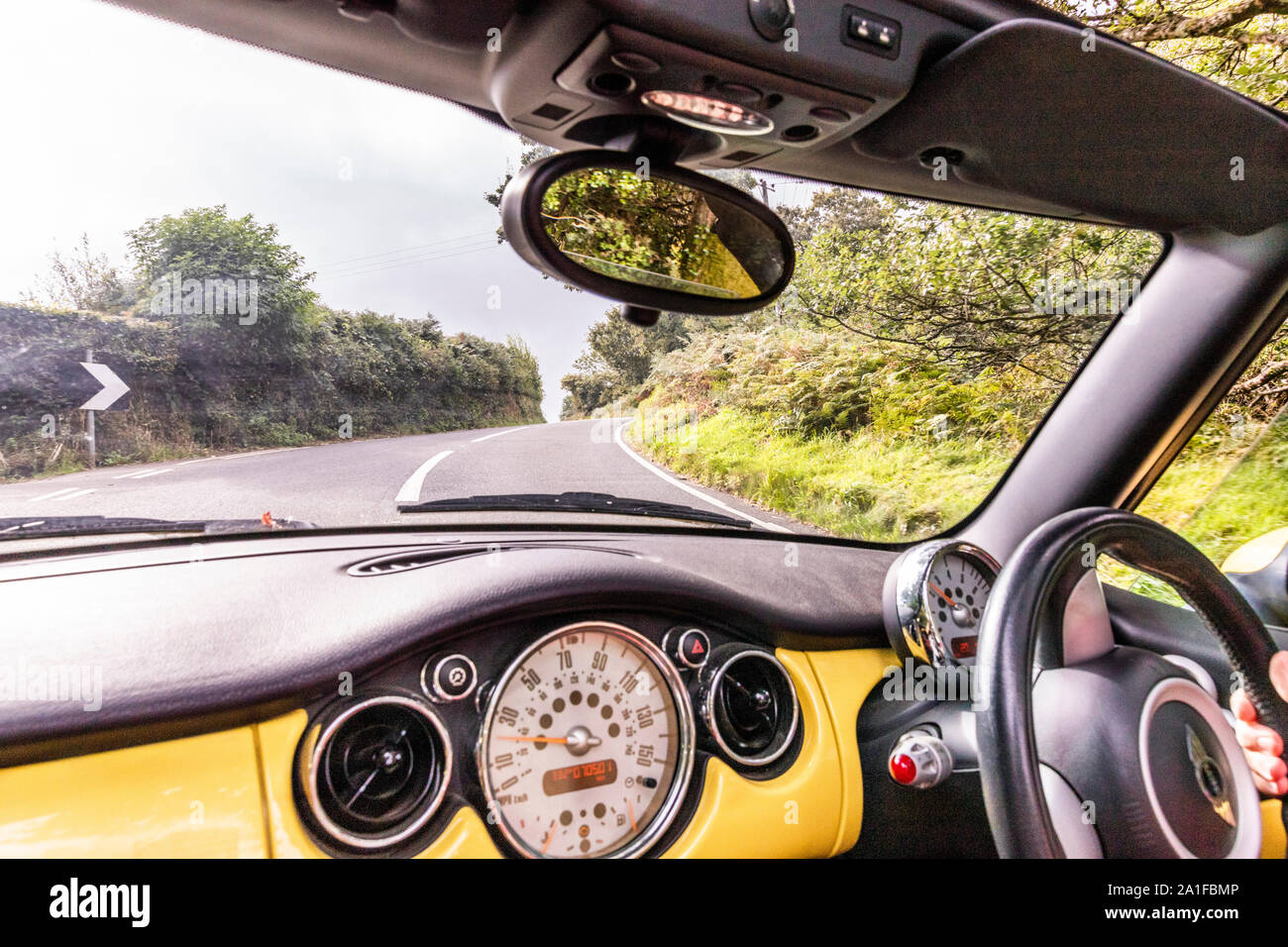 De l'avis de voyageurs d'une Mini Cooper décapotable jaune allant jusqu'Porlock Hill Somerset, Royaume-Uni Banque D'Images