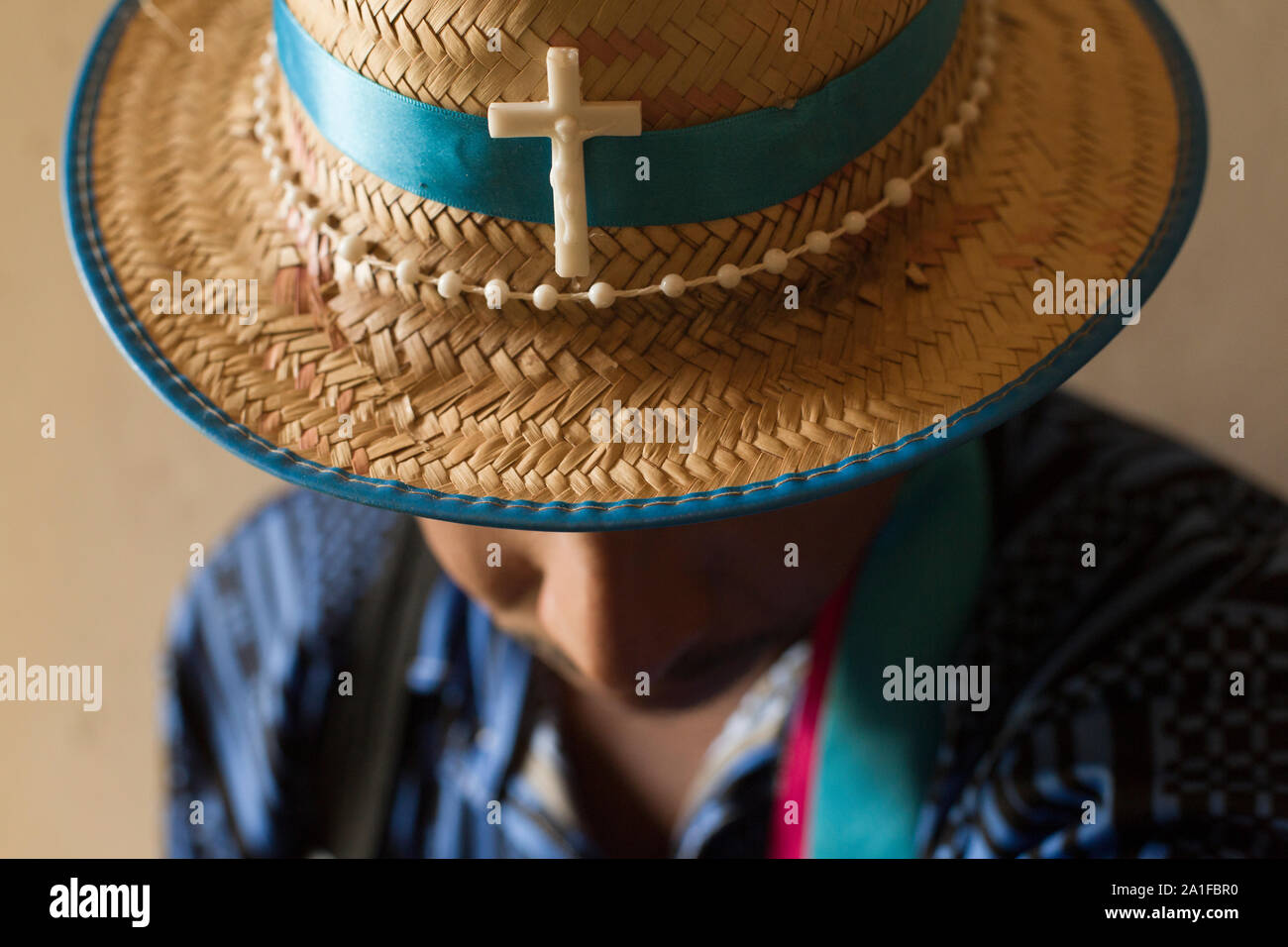 Man wearing straw hat brésilien avec Sainte Croix et chapelet autour de Banque D'Images