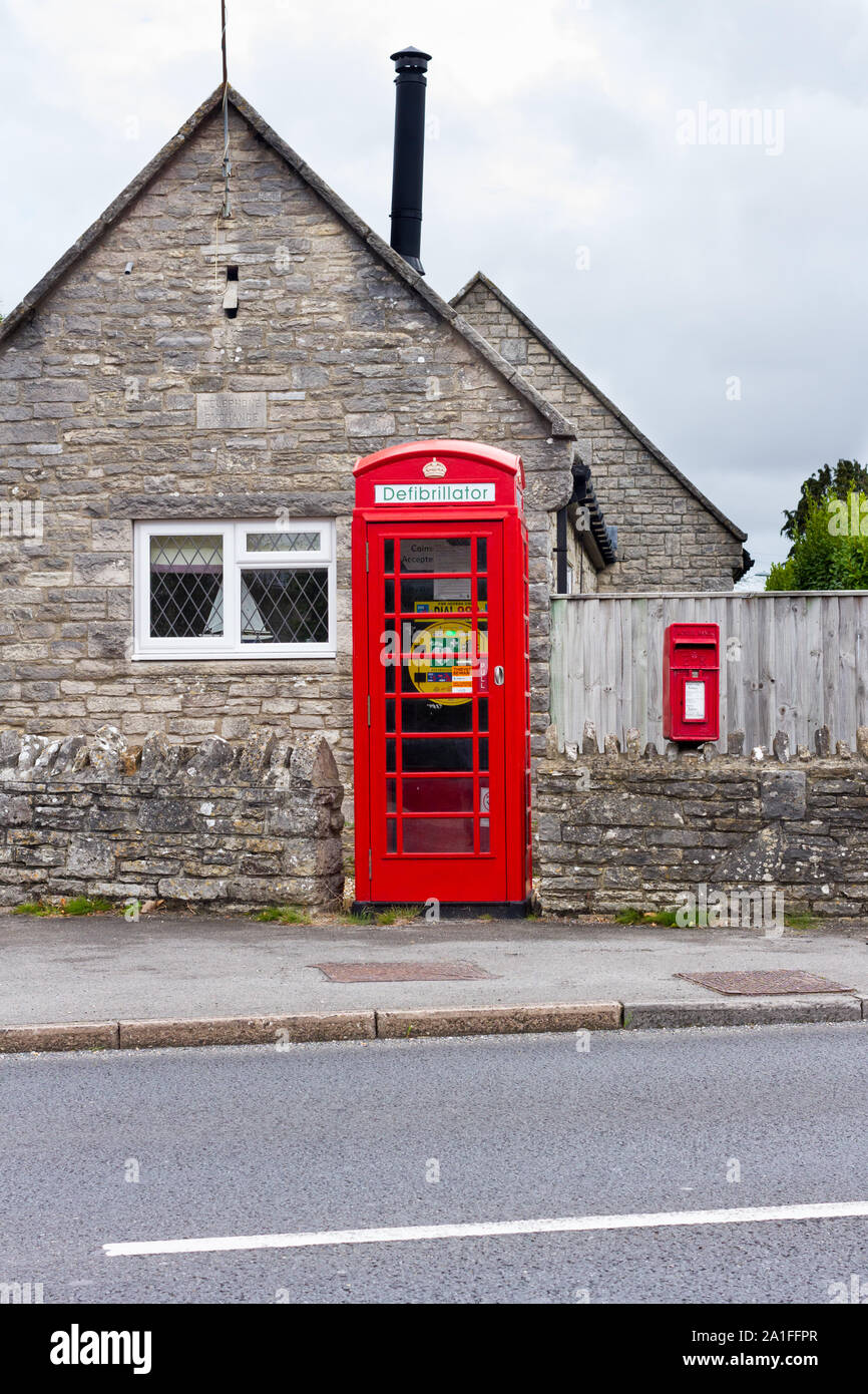 Défibrillation phone box. BT téléphone rouge fort transformé en life saving défibrillateur, route dans un village de Dorset, UK Banque D'Images