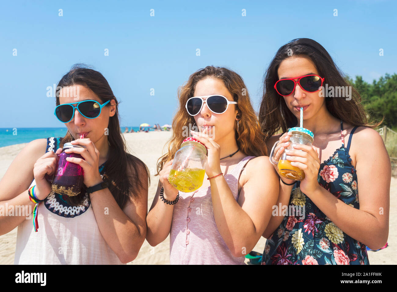 L'amitié et de loisirs concept - groupe de professionnels des jeunes femmes ou des femmes friends toasting sans alcool sur la plage d'été Banque D'Images