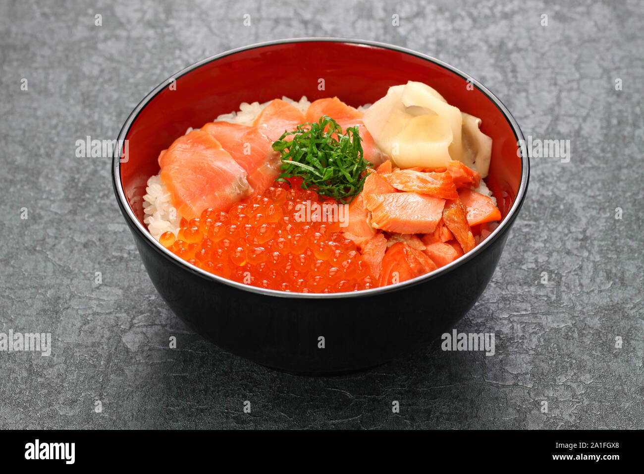 Bol de riz garni d'oeufs de saumon, du saumon et de la nourriture japonaise Banque D'Images