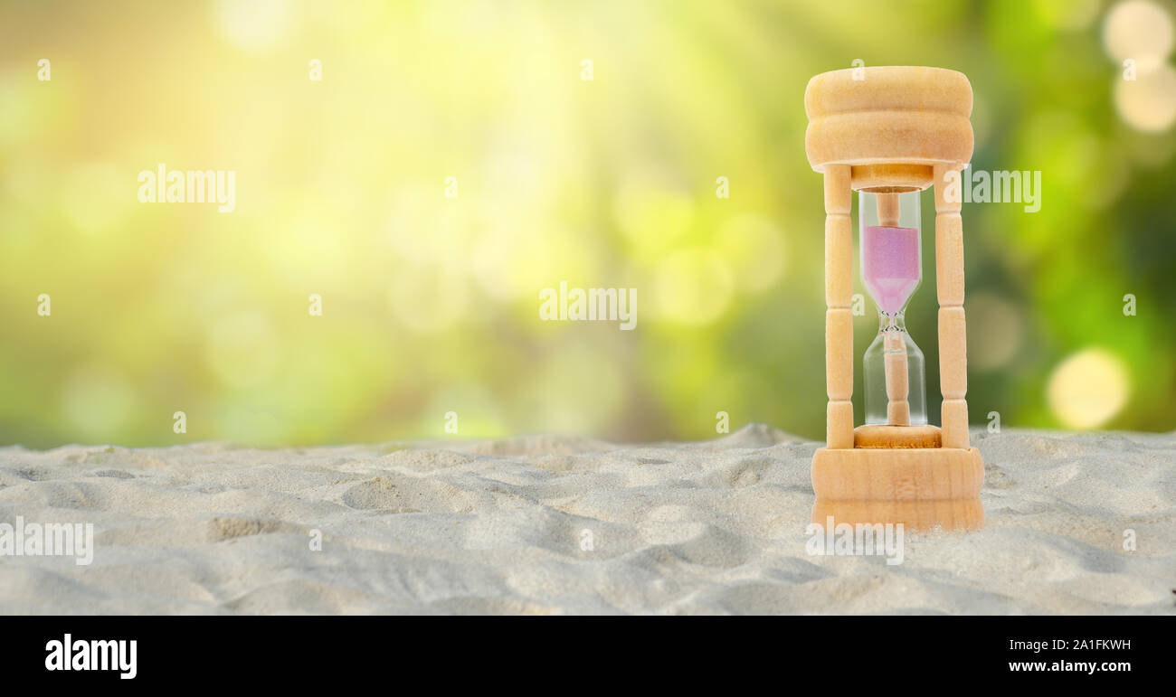 Jeu de Hourglass sur un fond de sable blanc, fond vert naturel, concept de temps Banque D'Images