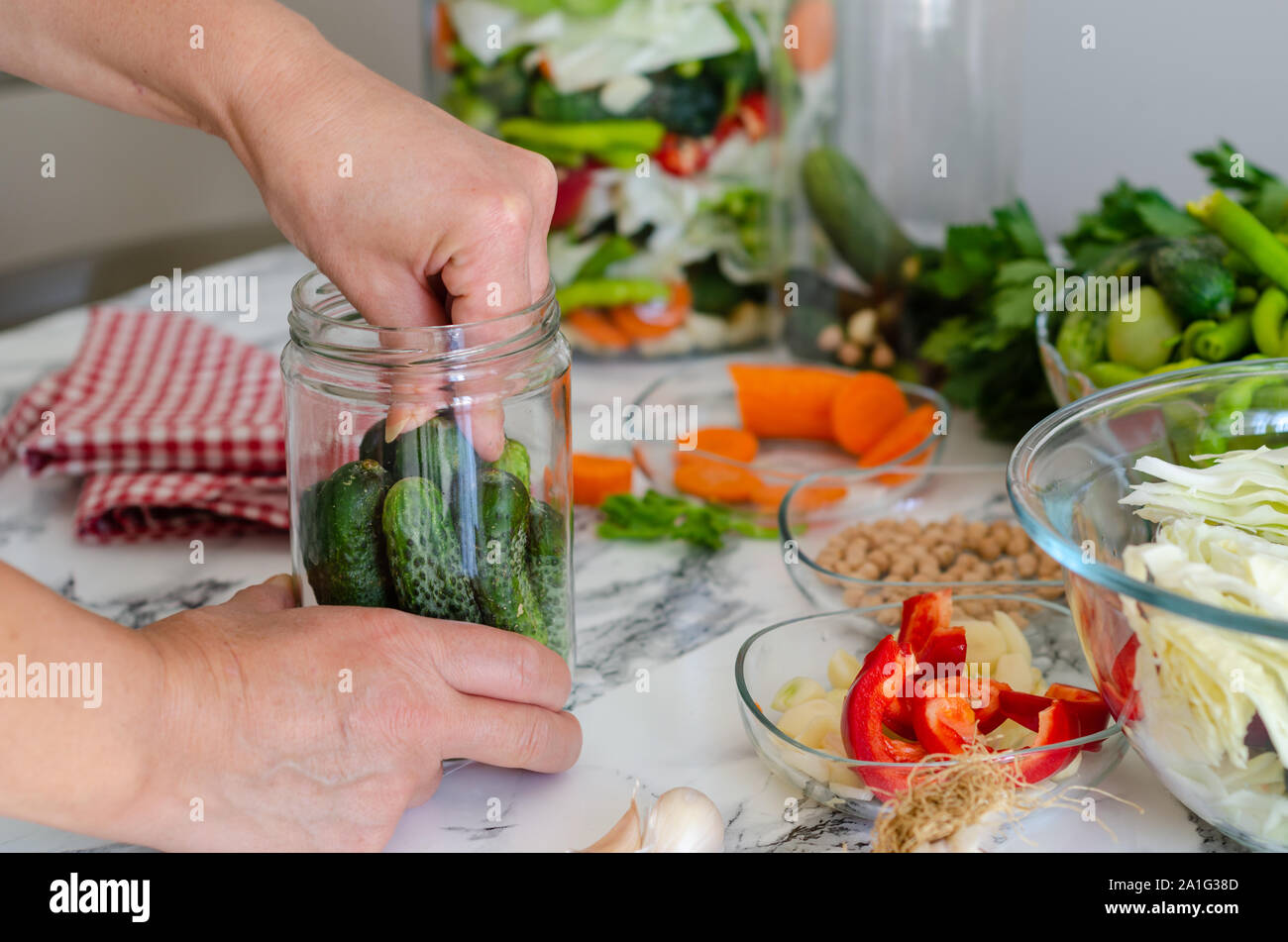 Les concombres avec l'ail, le sel et l'aneth pour le marinage . Dans le bocal de cornichons, des conserves de légumes. Banque D'Images