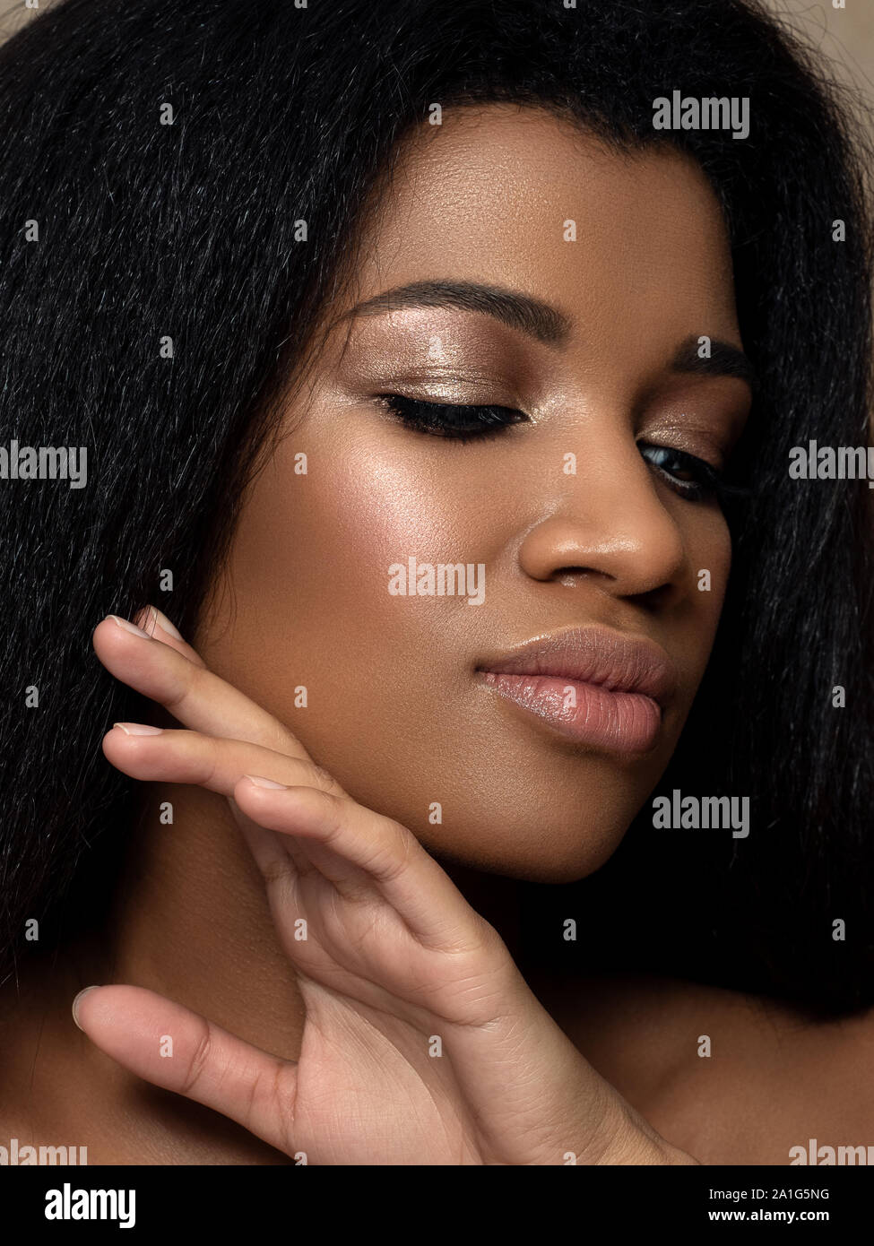Belle jeune femme noire touching her face Banque D'Images