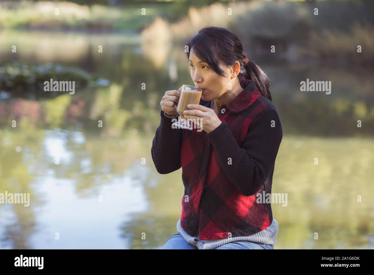 Une femme coréenne bénéficie d'une tasse de café sur une journée d'automne à Spokane, Washington. Banque D'Images