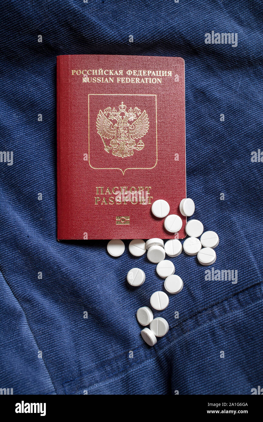 Passeport rouge du citoyen de la Fédération de Russie est sur un tissu de velours bleu, à côté de pilules médical blanc éparpillés Banque D'Images