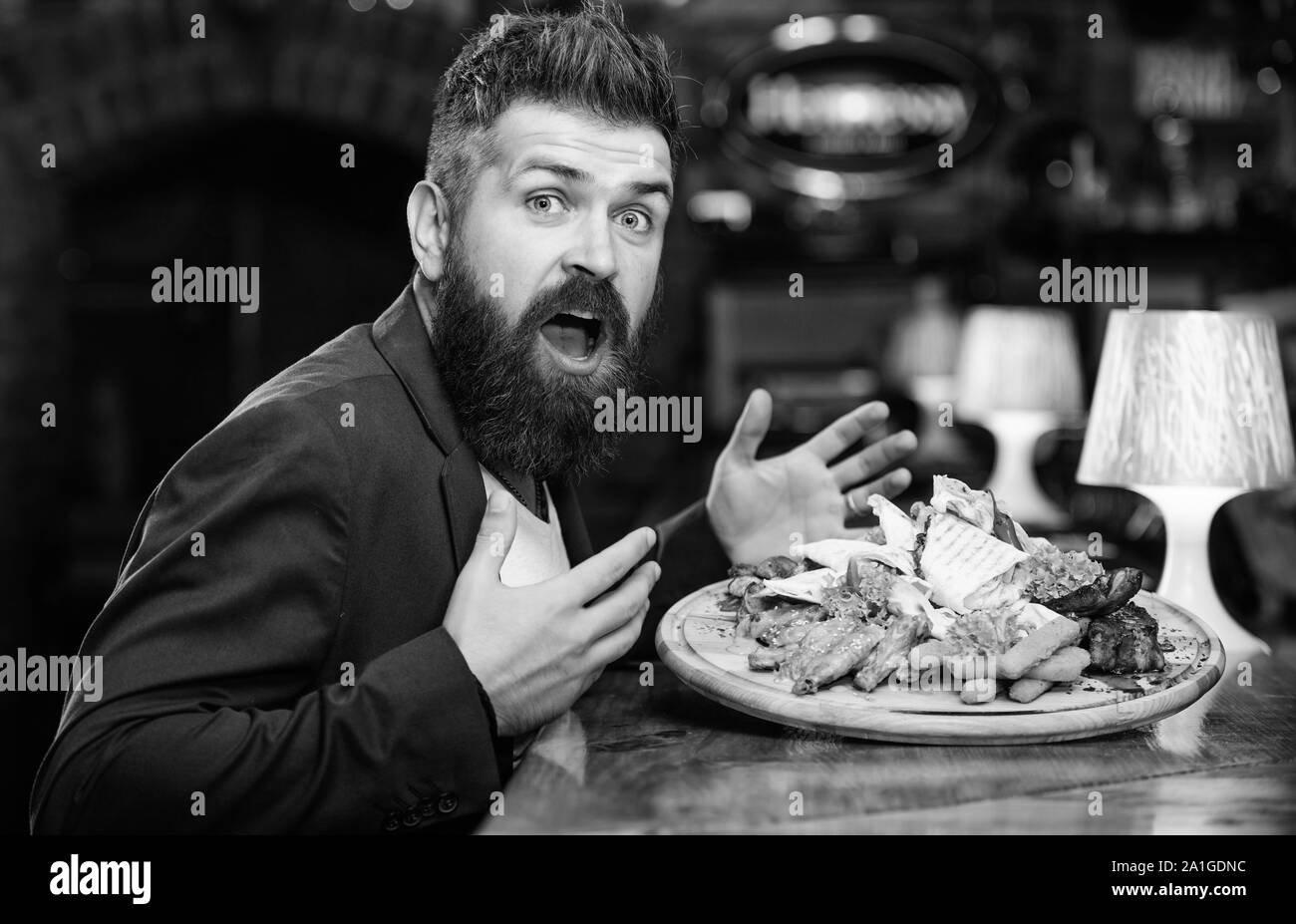 Woman costume formel s'asseoir au restaurant. L'homme a reçu de pommes de terre frites repas avec les bâtonnets de poisson viande. Il méritent de délicieux repas. Profitez de votre repas. Des calories. Vous pourrez vous détendre après une dure journée. La nourriture délicieuse. Banque D'Images