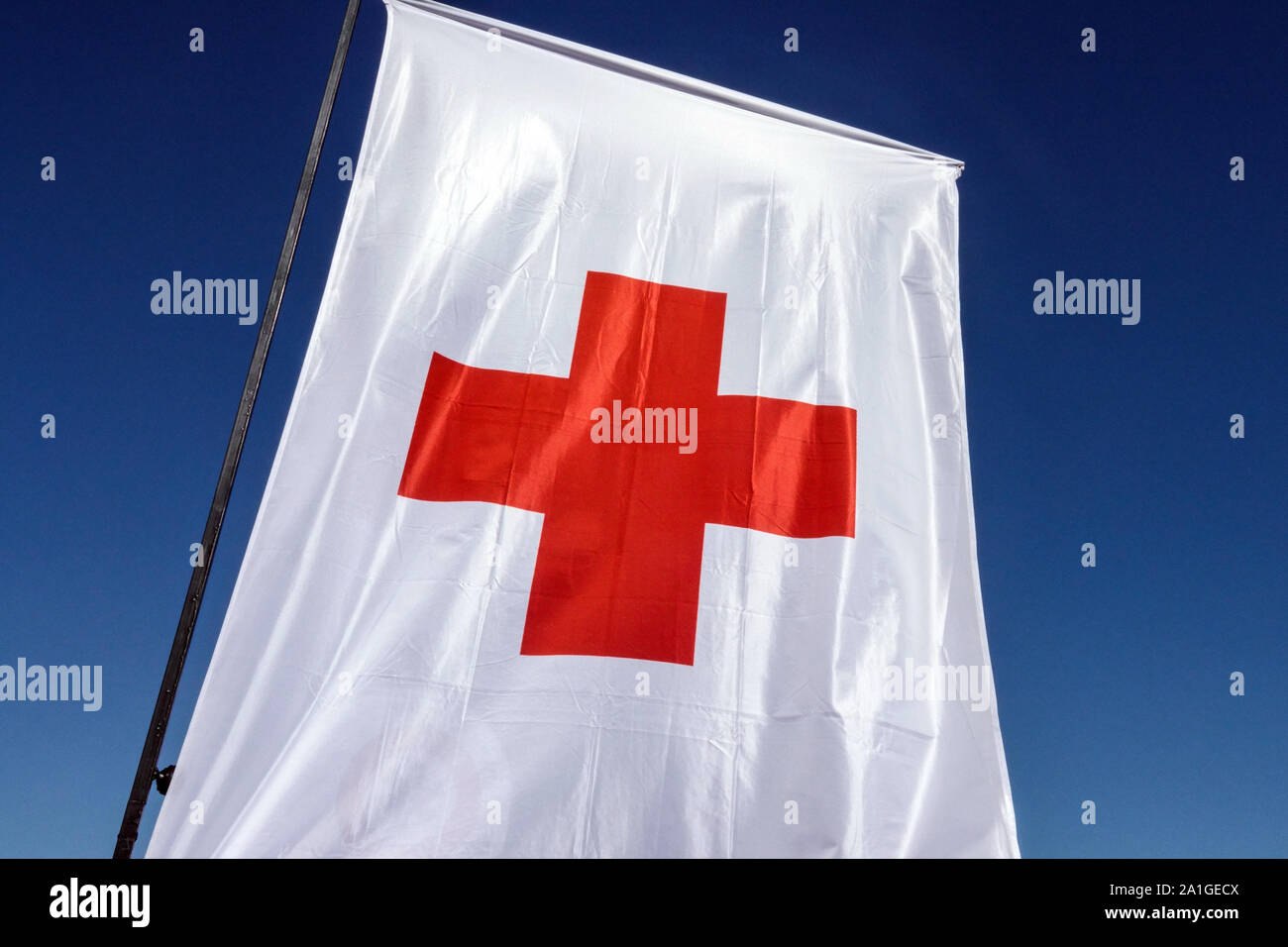 Mât de drapeau de croix rouge contre le ciel bleu Banque D'Images