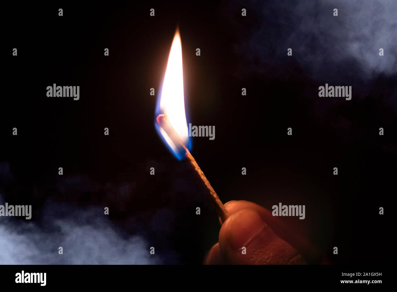 Main tenant burning match stick avec de la fumée . Banque D'Images