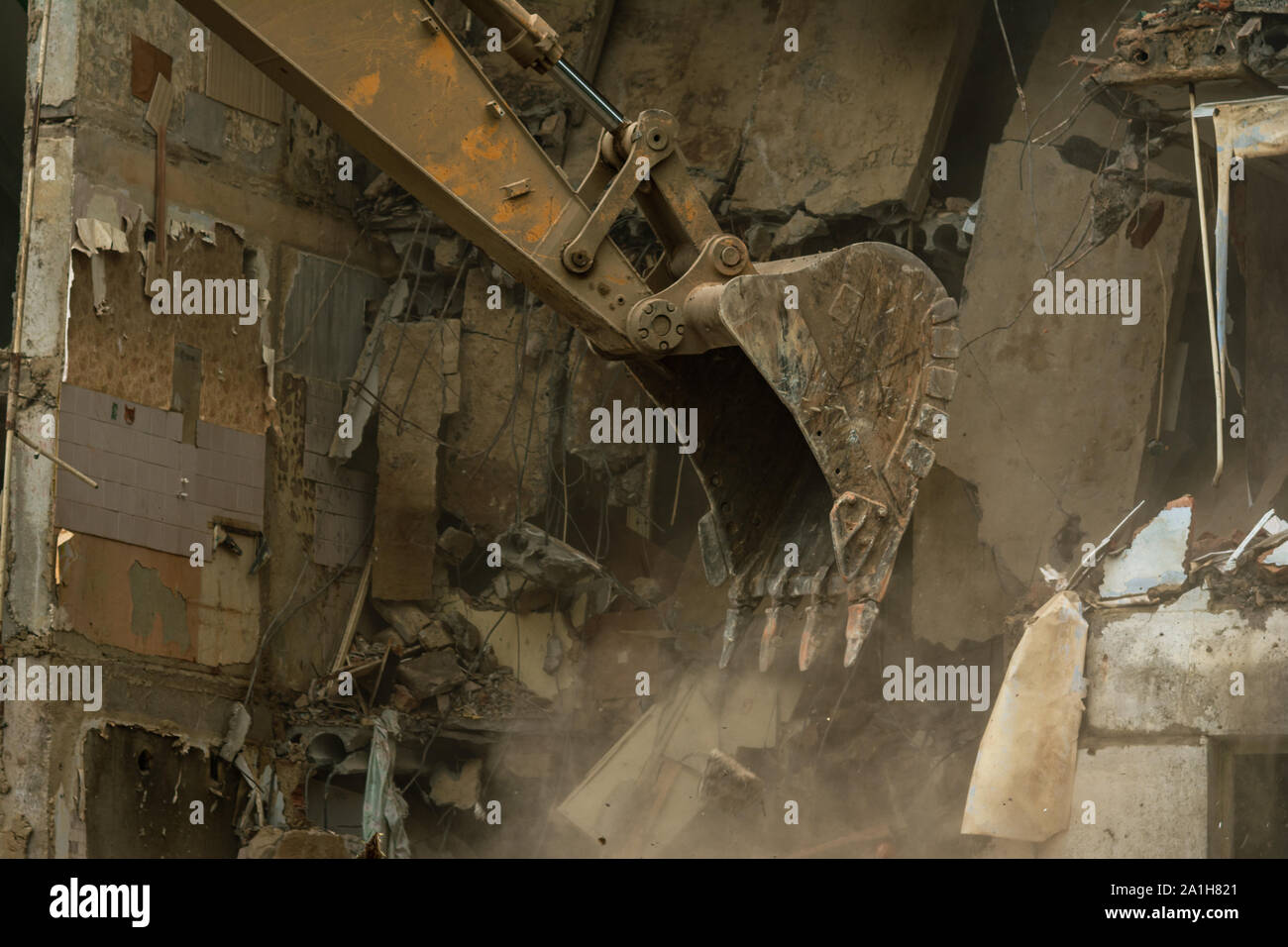 Démolition d'un immeuble de cinq étages, reconnu comme un logement d'urgence, close-up d'un godet recueille les déchets de construction Banque D'Images