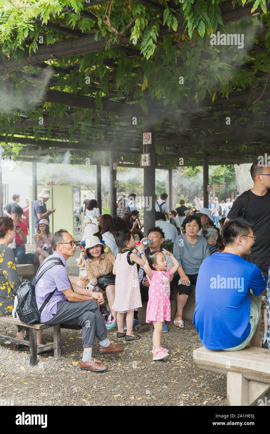 Le groupe de touristes se détendre sous un brouillard tournage cabana pour échapper à la chaleur de l'été à Tokyo dans le Temple Senso-ji, Tokyo, Japon. Banque D'Images