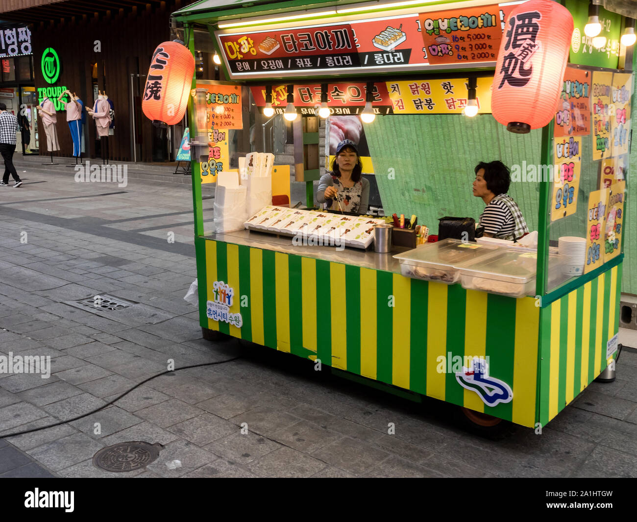 Suwon, Corée du Sud - 15 juin 2017 : Vendeur femme en attente d'acheteurs dans son kiosque de restauration rapide au main street à Suwon. Banque D'Images