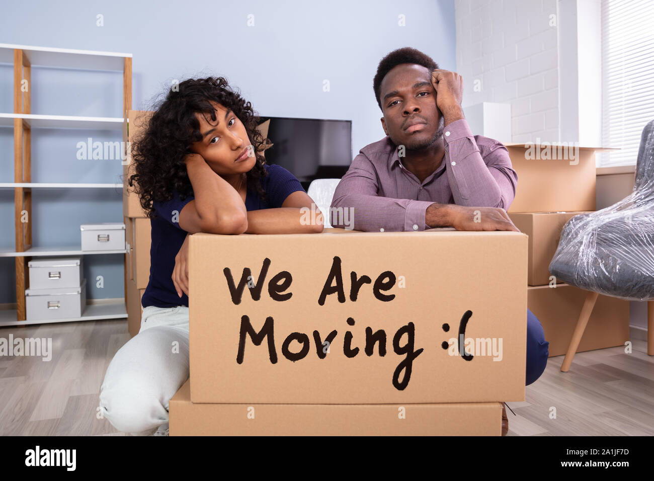 Souligné Couple Sitting près de boxes in New Home Banque D'Images