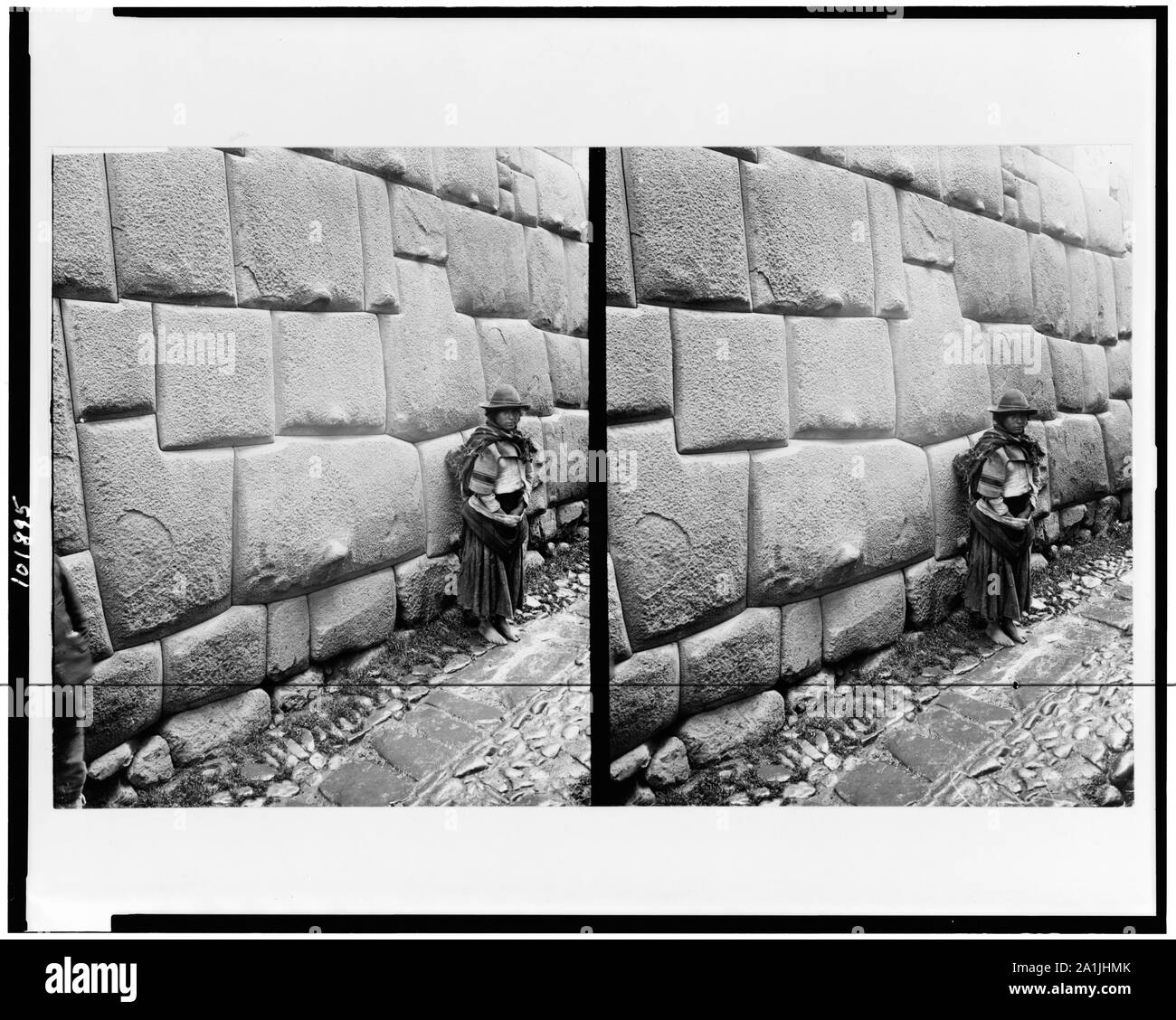Comité permanent autochtone par mur de maçonnerie Inca, Cuzco, Pérou Banque D'Images
