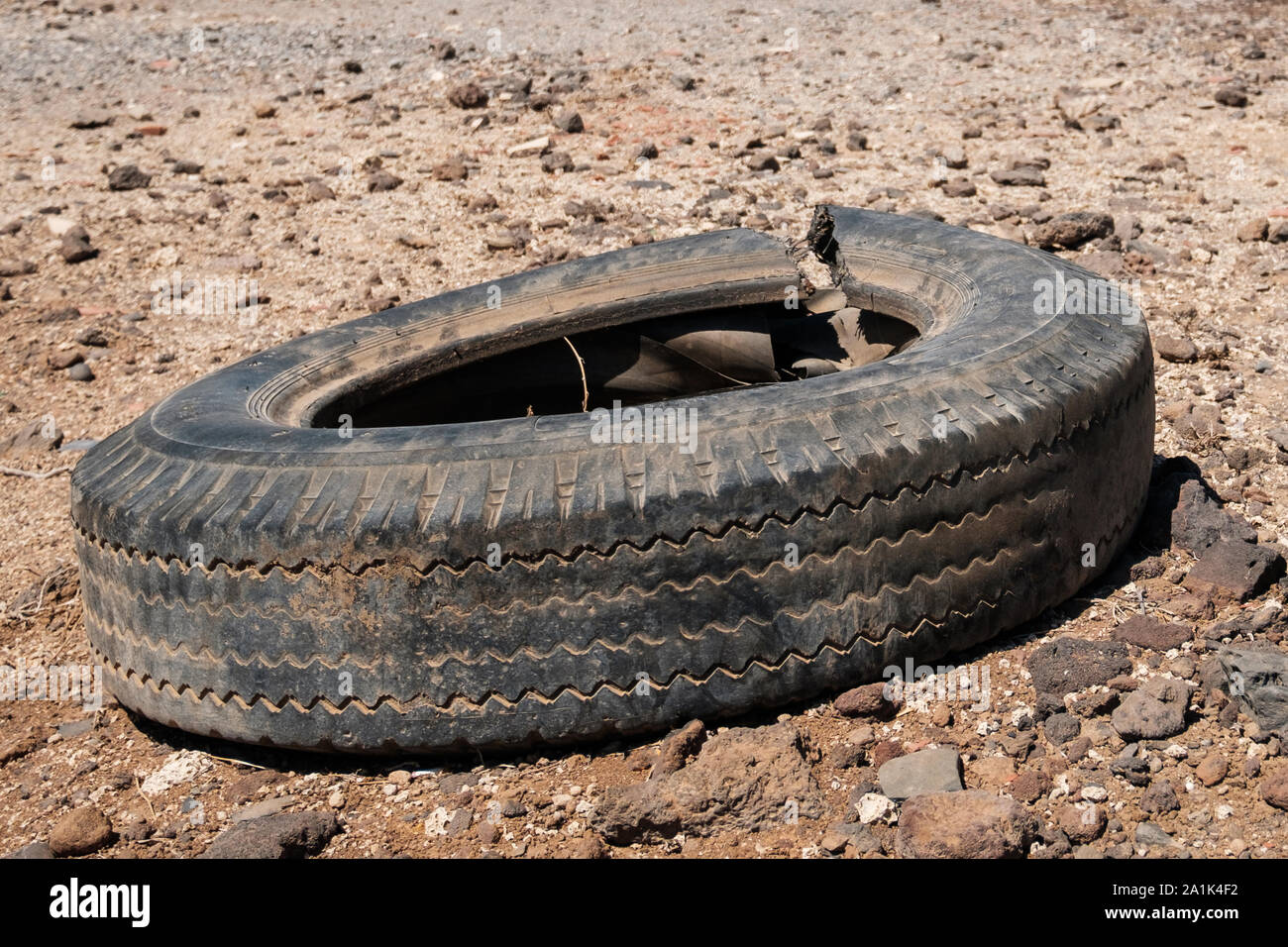 Pneu de voiture ancienne dans paysage de désert isolé Banque D'Images