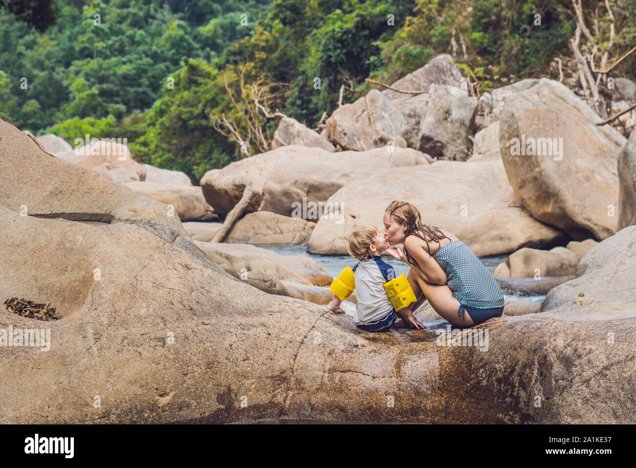 Maman et jeune fils sur fond de pierres et d'une rivière. Concept voyager avec des enfants Banque D'Images