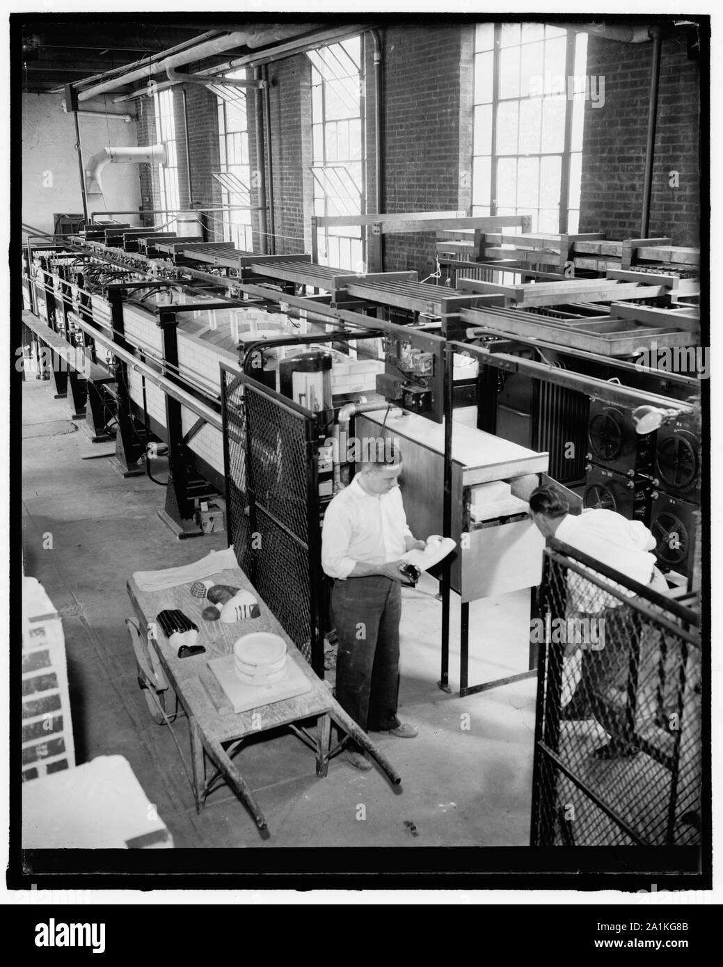 Nouvelle méthode de la poterie. Washington, D.C., le 17 juin. Réception de fin de la nouvelle résistance électrique avec four tunnel de 45 pieds au National Bureau of Standards. Ce four permet de fire pottery en aussi peu que 16 heures par rapport à 2 et 3 jours ou plus dans les anciens types de fours, l'image montre une poterie émaillée retiré du four tandis que les échantillons pour les tests scientifiques sont sur le chariot prêt à aller à la physical laboratory, R.F. Geller, du Bureau des normes sur la gauche est le concepteur et le constructeur du four, c'est assisté par W.W. Myers, sur la droite, 6/17/38 Banque D'Images