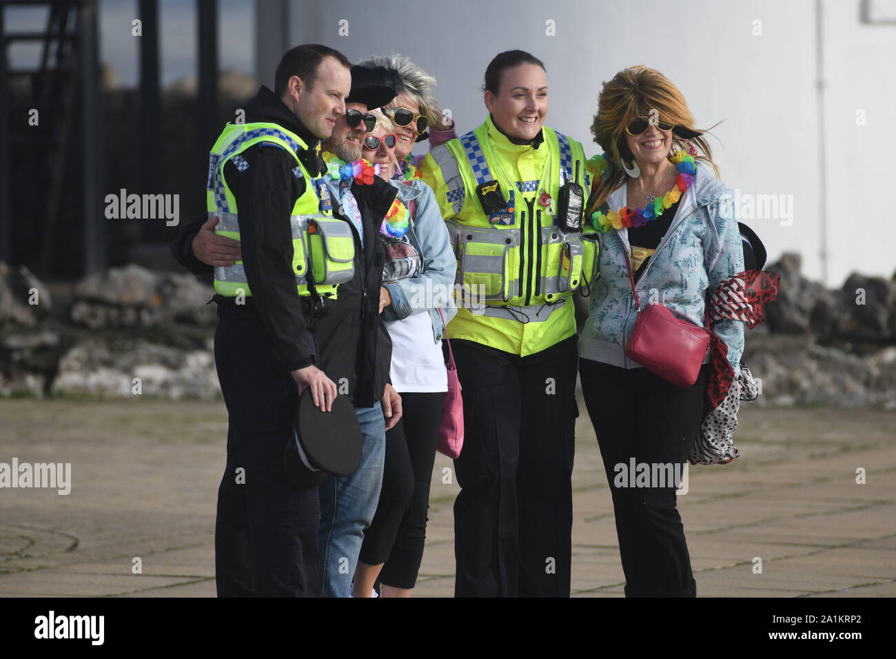 Porthcawl, Pays de Galles, Royaume-Uni. Vendredi 27 avril, 2019 septembre. Les gens en photo arrivant à Porthcawl en Galles du Sud ont leur photo prise avec des agents de police au début du Festival Elvis annuel. Dans le cadre de cette compétition, des milliers de personnes descendent sur la ville balnéaire de prendre part au plus grand Festival Elvis de son genre en Europe, pour célébrer la vie et de la musique du roi. Il y a plus de 100 spectacles et événements à travers 20 endroits autour de la ville, notamment des spectacles et des concours de costumes. Crédit photo : Robert Melen/Alamy Live News Banque D'Images