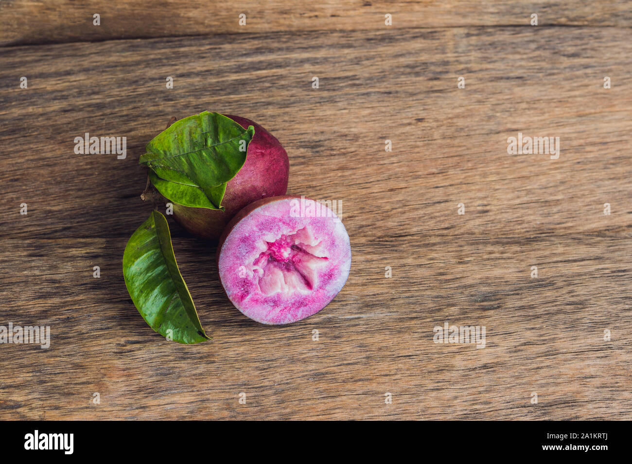 Fruits frais de Chrysophyllum cainito sur fond de bois Banque D'Images