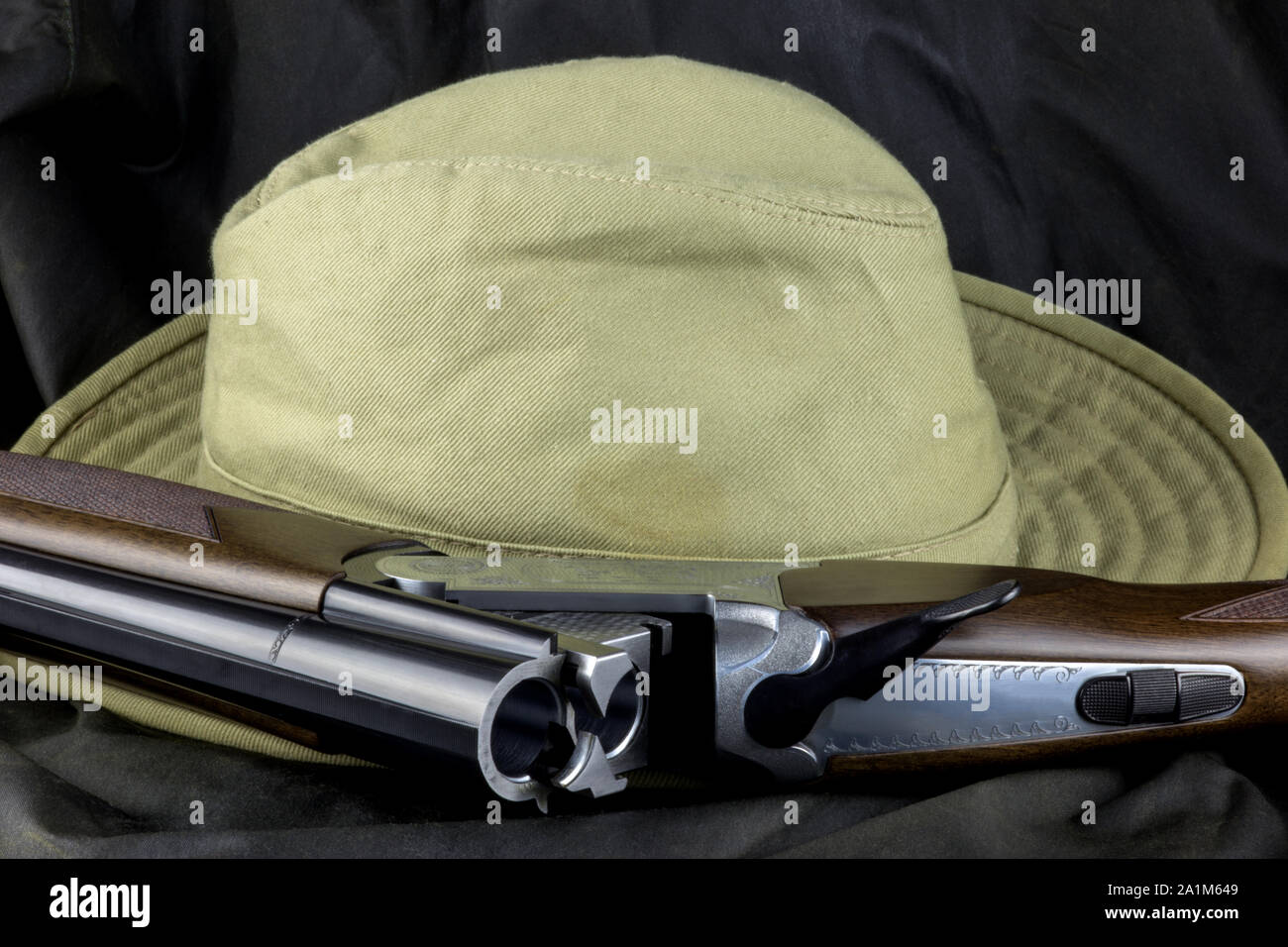 Shotgun et bush hat sur un manteau extérieur contexte Banque D'Images