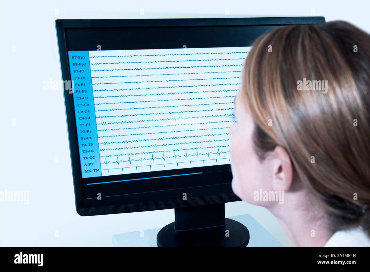 Professionnel de la santé des femmes à la recherche de l'EEG (électroencéphalogramme) résultats à l'écran. Banque D'Images