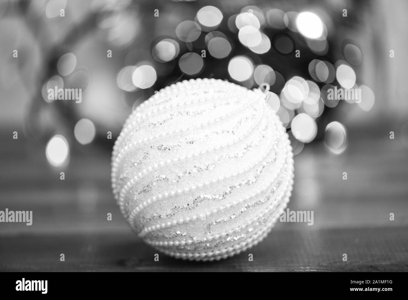 Ornement boule bleu sur surface en bois. Choisissez un décor coloré pour arbre de Noël. Ornement de Noël Boule unique sur l'arrière-plan flou artistique garland lumières colorées. Ornements de Noël concept. Banque D'Images