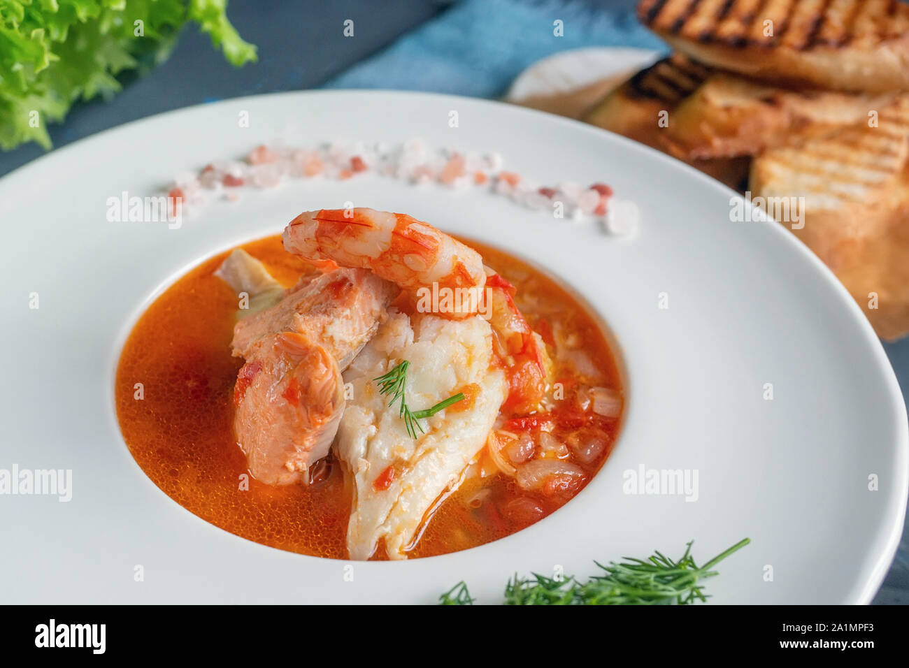 Soupe régime alimentaire de fruits de mer et poissons de différentes variétés dans une assiette blanche. Close up. Banque D'Images