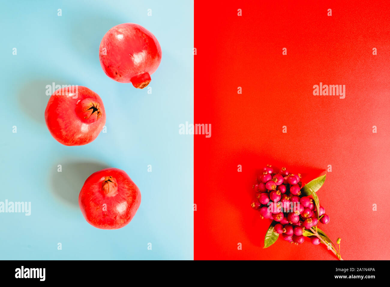 Composition symétrique avec le rouge et le fond bleu, et le contraste des fruits de grenade. Banque D'Images