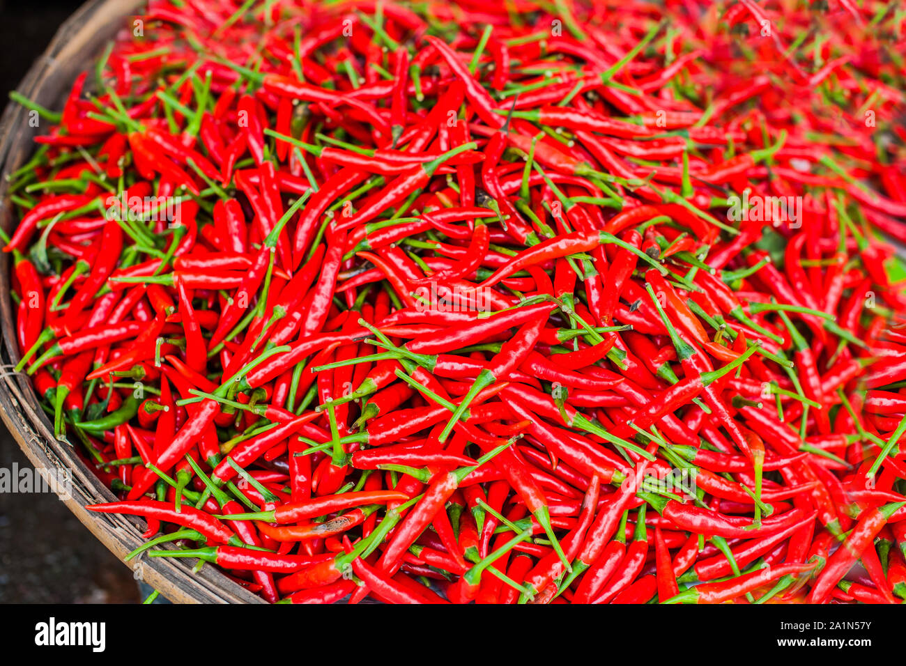 Petits piments rouges dans le panier en osier du Marché vietnamien Banque D'Images