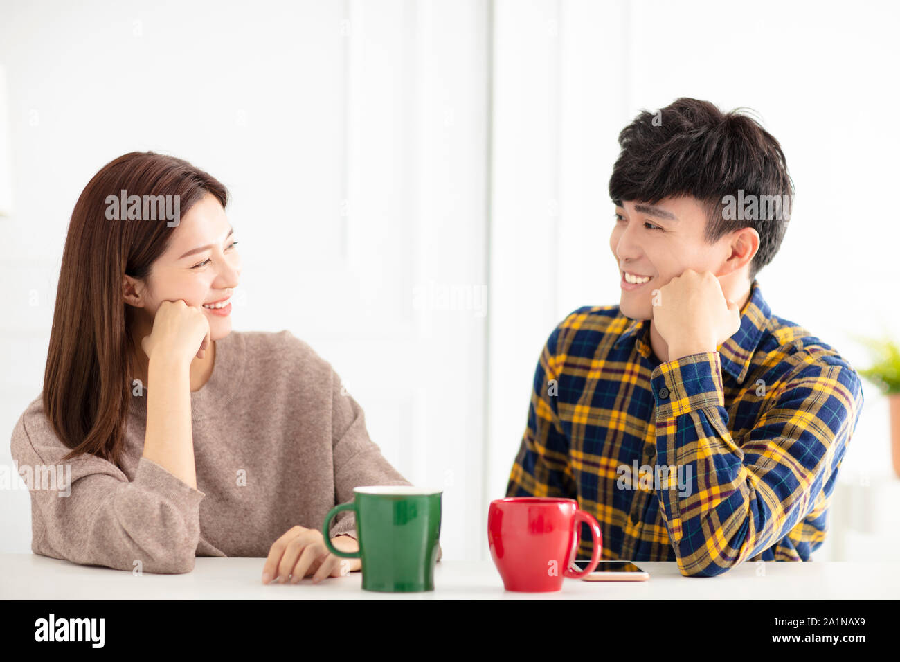 Happy young couple parler et rire, de boire du thé. Banque D'Images