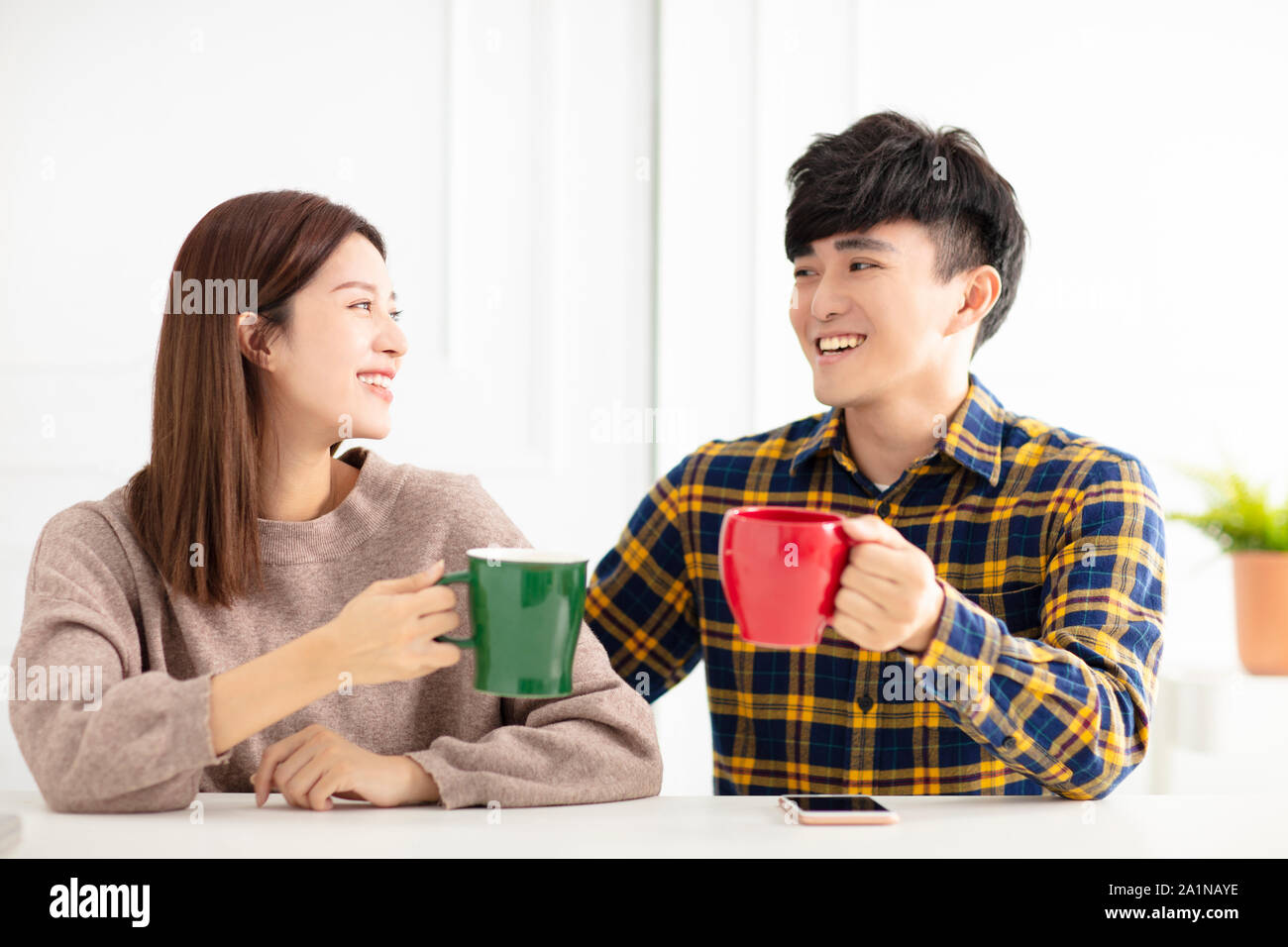 Happy young couple parler et rire, de boire du thé. Banque D'Images