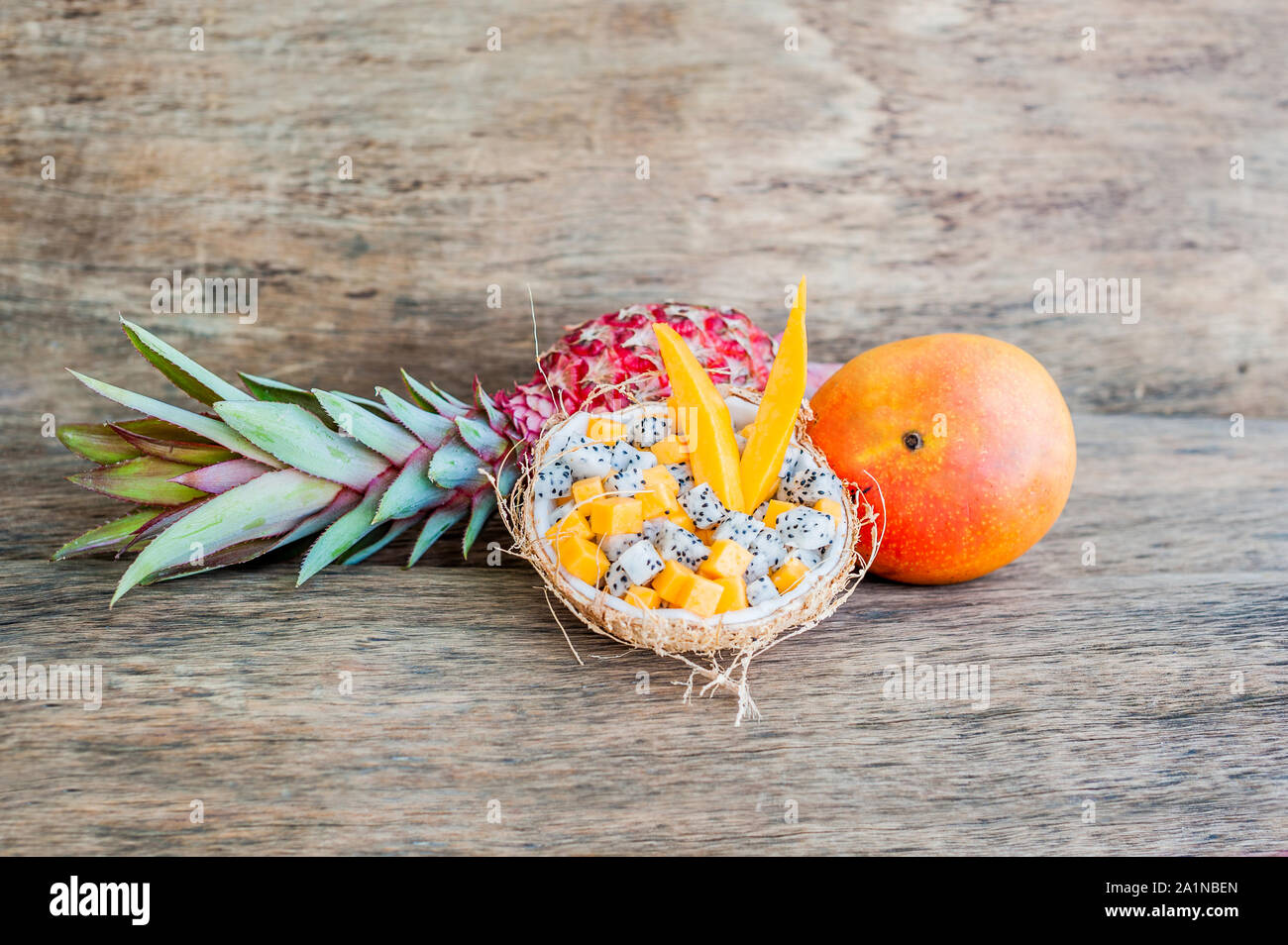 Salade de fruits avec fruits de dragon et papaye en demi noix de coco Banque D'Images