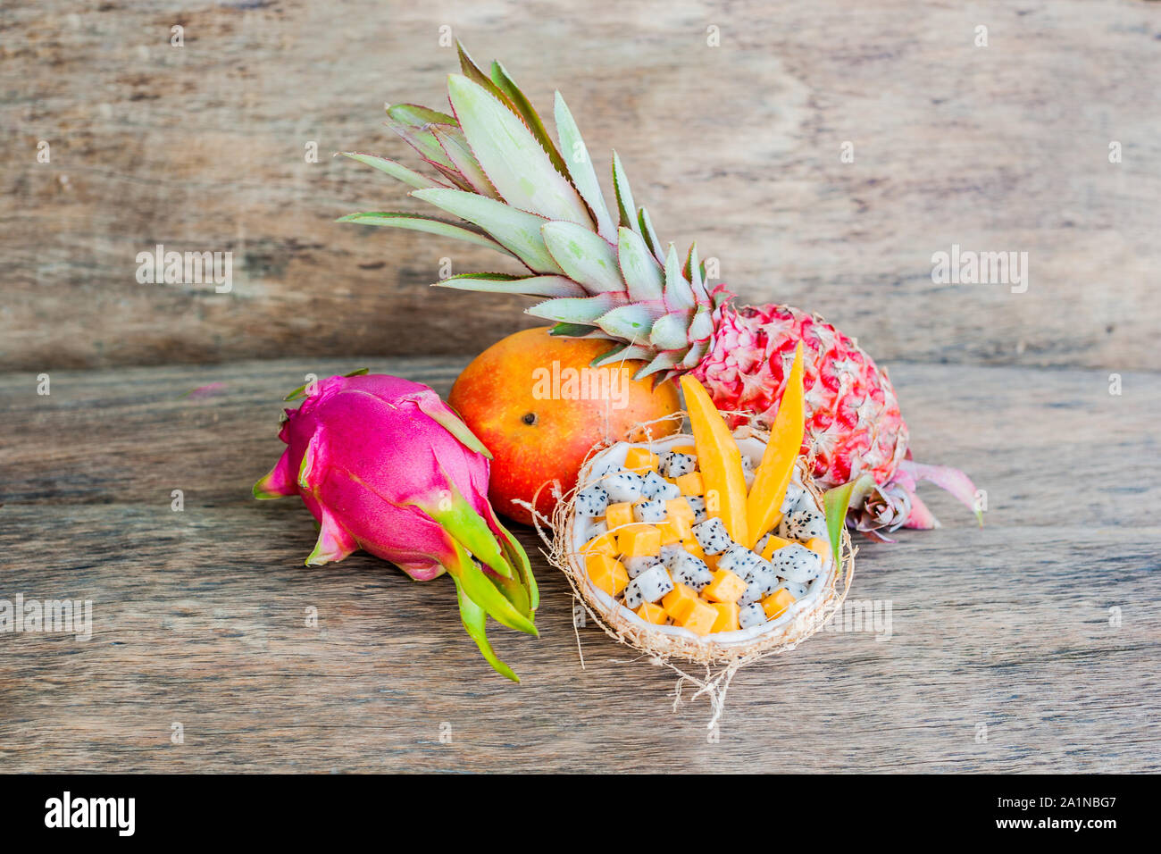 Salade de fruits avec fruits de dragon et papaye en demi noix de coco Banque D'Images