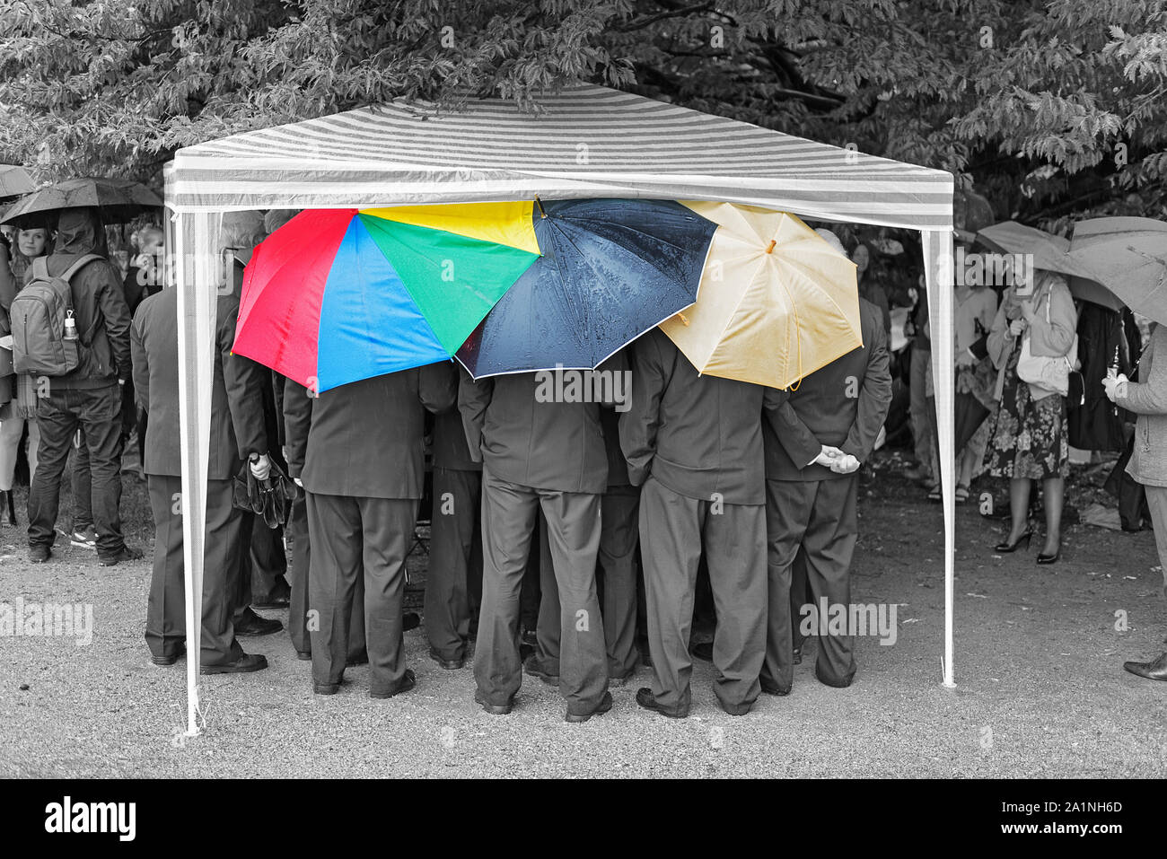 Un groupe d'hommes en costumes sombres sous égide Banque D'Images