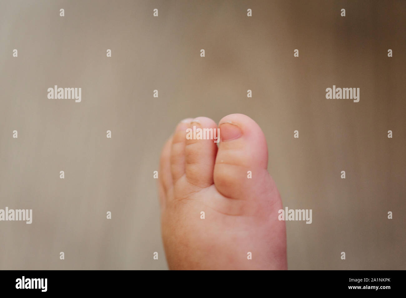 Tout petit bébé pied blanc close up on a wooden background Banque D'Images