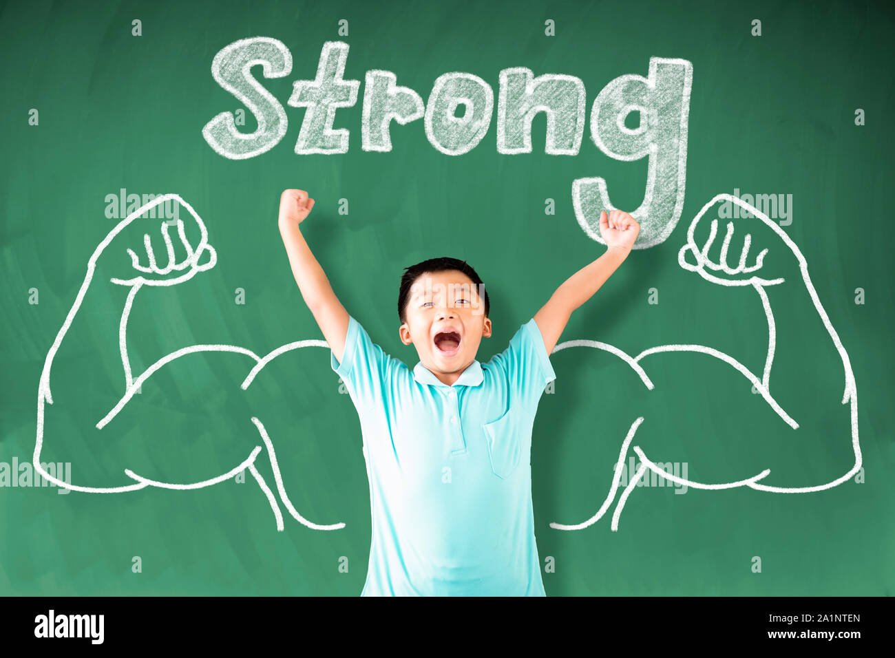 Asian boy standing contre tableau et forte concept gagnant Banque D'Images