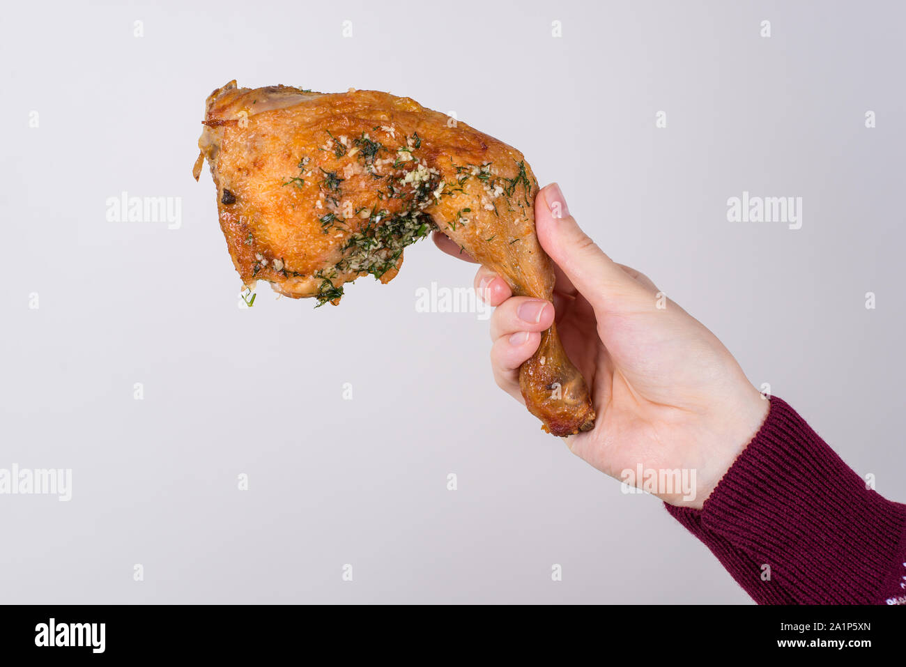 Tourné recadrée photo gros plan de la main grasse d'étirement délicieux délicieux poulet aux épices délicieux fond gris isolé copy space Banque D'Images