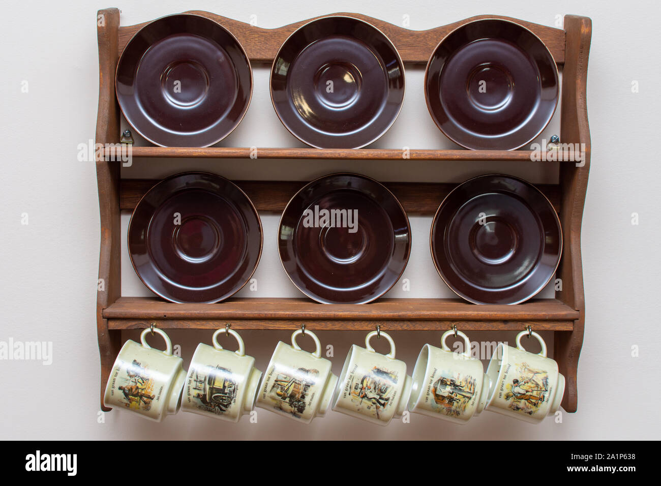 Tasses et assiettes néerlandais hanging on a rustic wooden frame sur le mur. Culture de Holland aux Pays-Bas. Dans les maisons communes. Banque D'Images