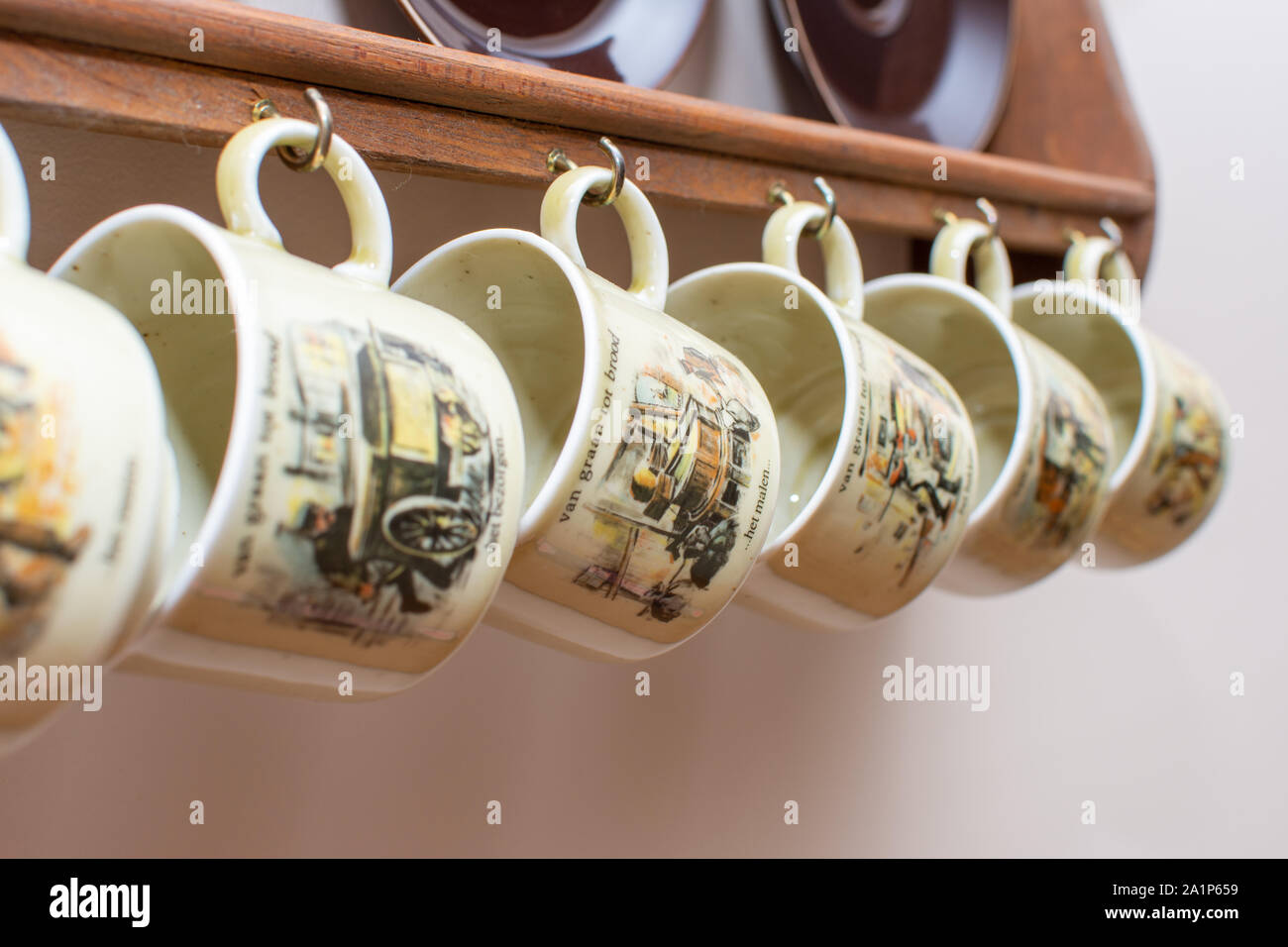 Tasses et assiettes néerlandais hanging on a rustic wooden frame sur le mur. Culture de Holland aux Pays-Bas. Dans les maisons communes. Banque D'Images